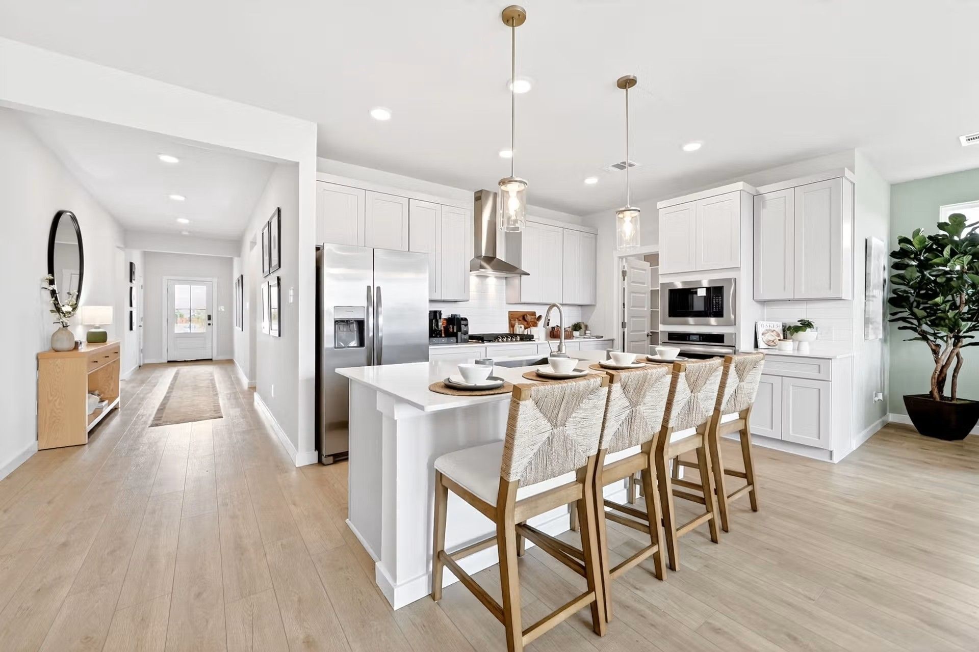 Modern white kitchen with island seating in The Laurel I floor plan by Davidson Homes in Heartland, Texas.