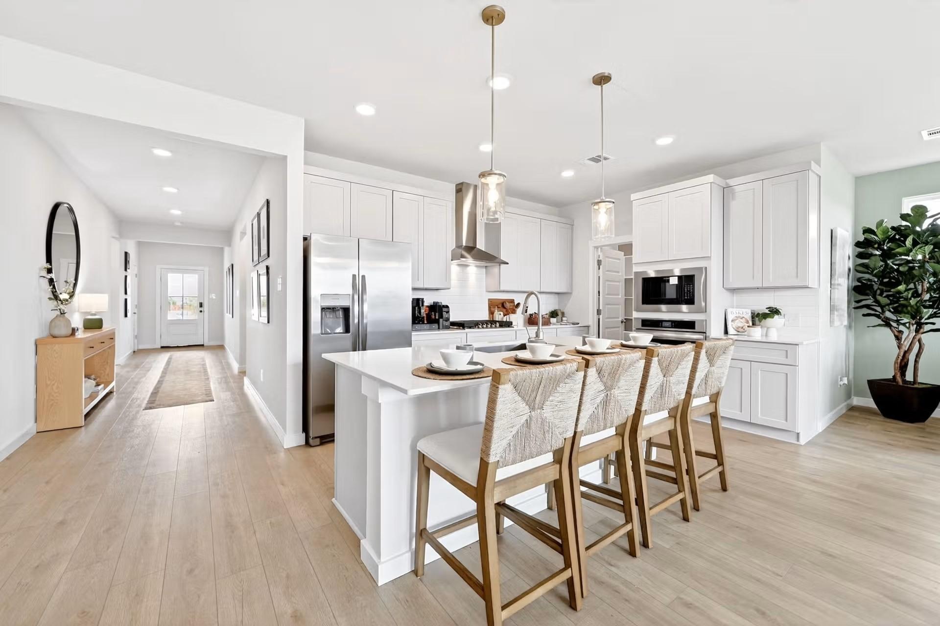 Modern white kitchen with island seating in The Laurel I floor plan by Davidson Homes in Heartland, Texas.