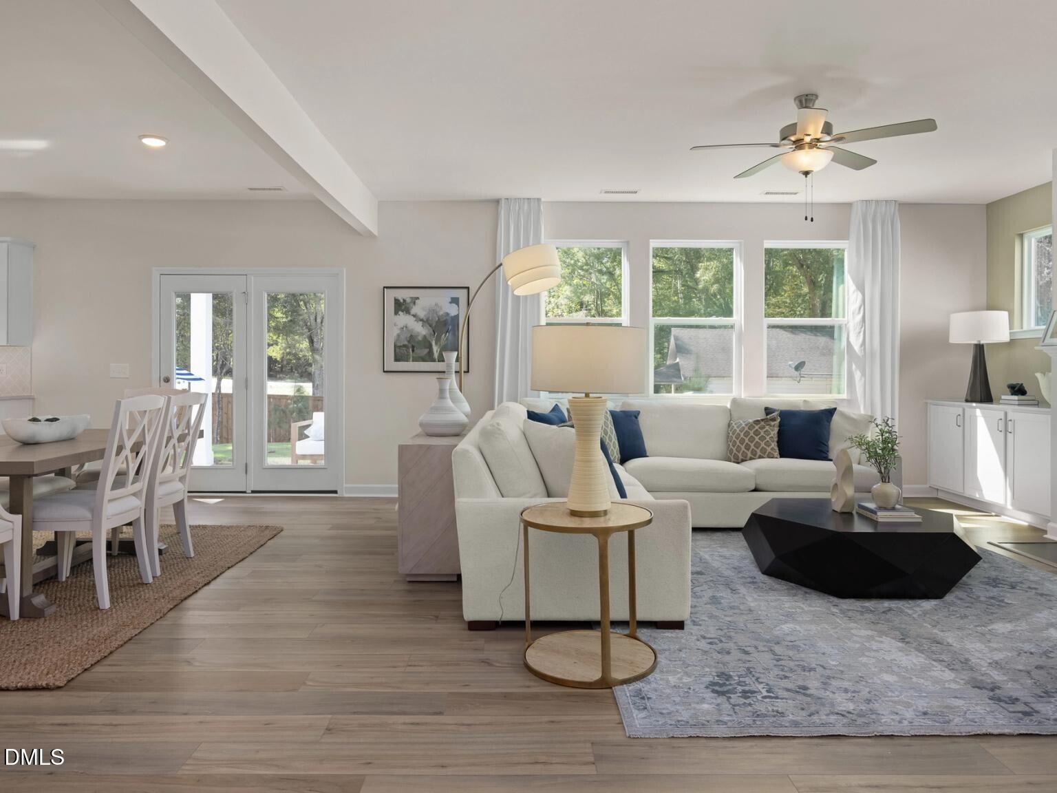 Cozy living room with beige sectional sofa, hexagonal coffee table, dining nook, and French doors to backyard in Davidson Homes The Hickory II D, Wake Forest