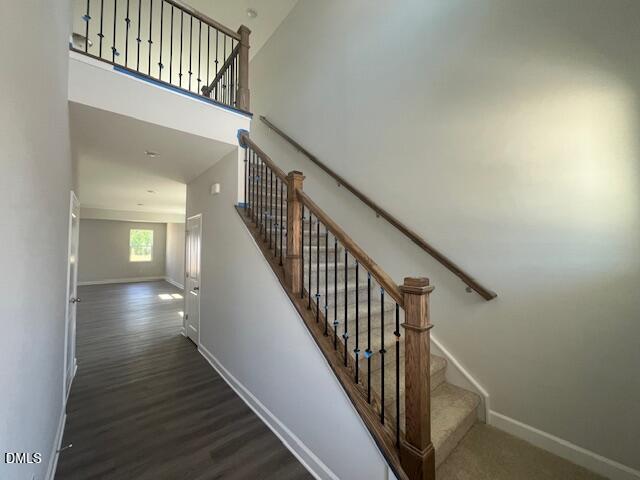 Grand two-story foyer with elegant wooden staircase and iron balusters in The Adalynn A home, Lillington, NC