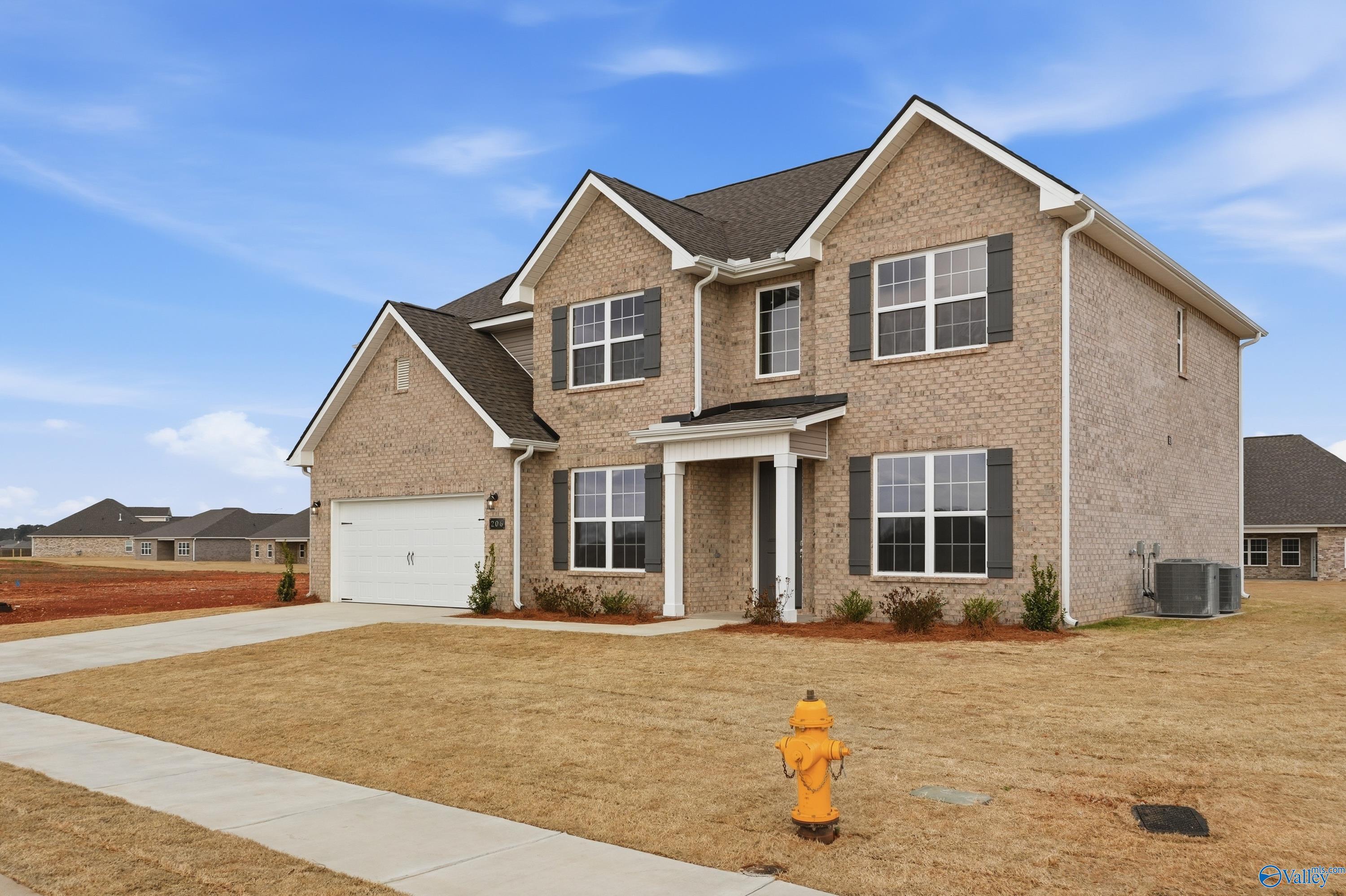 Two-story brick home with 2-car garage, front porch, and landscaped yard in Pikes Ridge, Meridianville, Alabama - Davidson Homes The Madison A