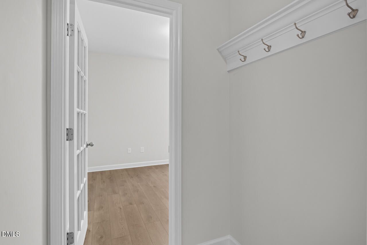 Mudroom entry with coat hooks and French door opening to hardwood flooring in Davidson Homes The Daphne D, Zebulon, NC