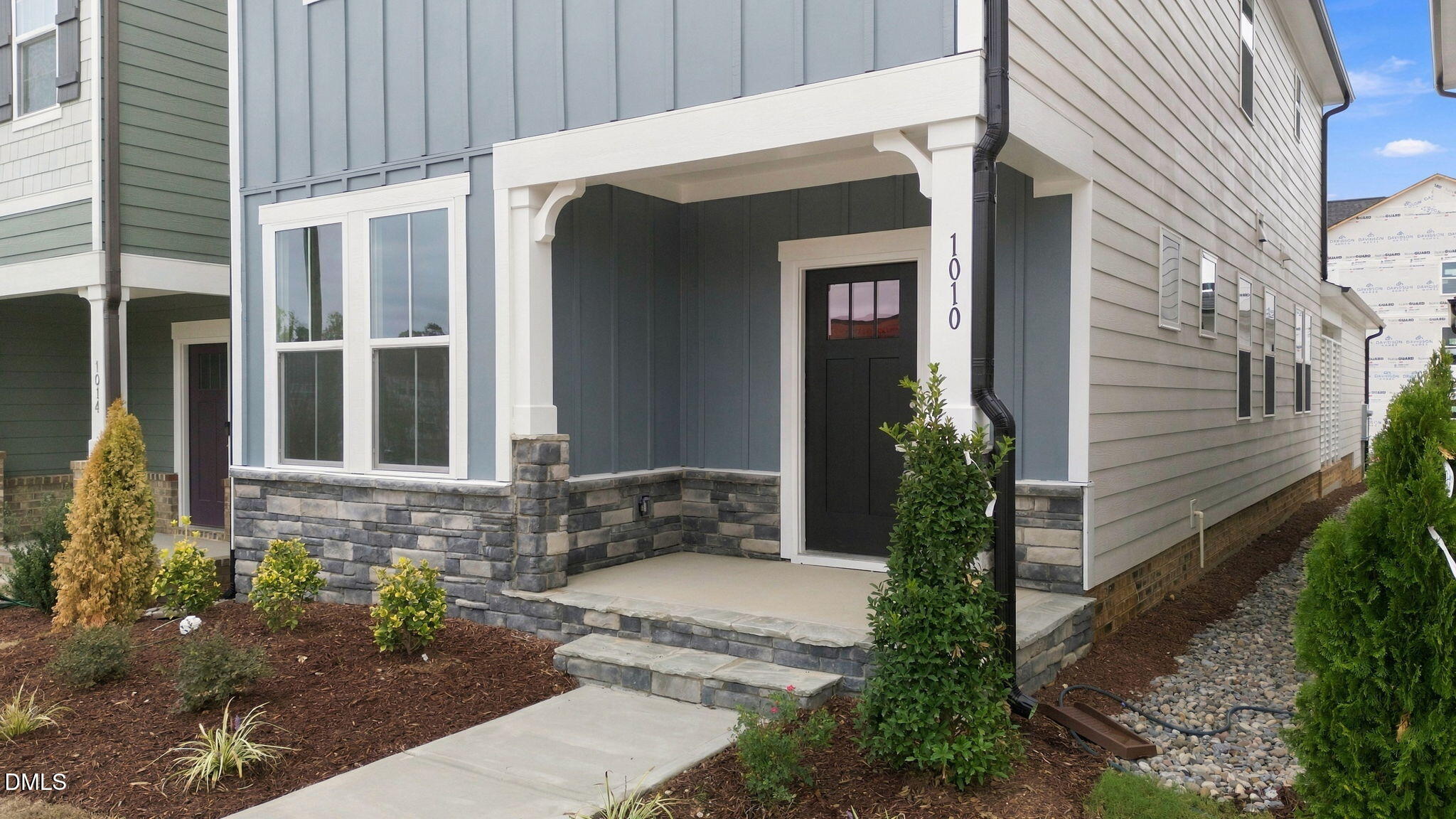 Covered front porch with stone accents on 2-story Davidson Homes Alexander B plan in Forestville Yard, Knightdale, North Carolina