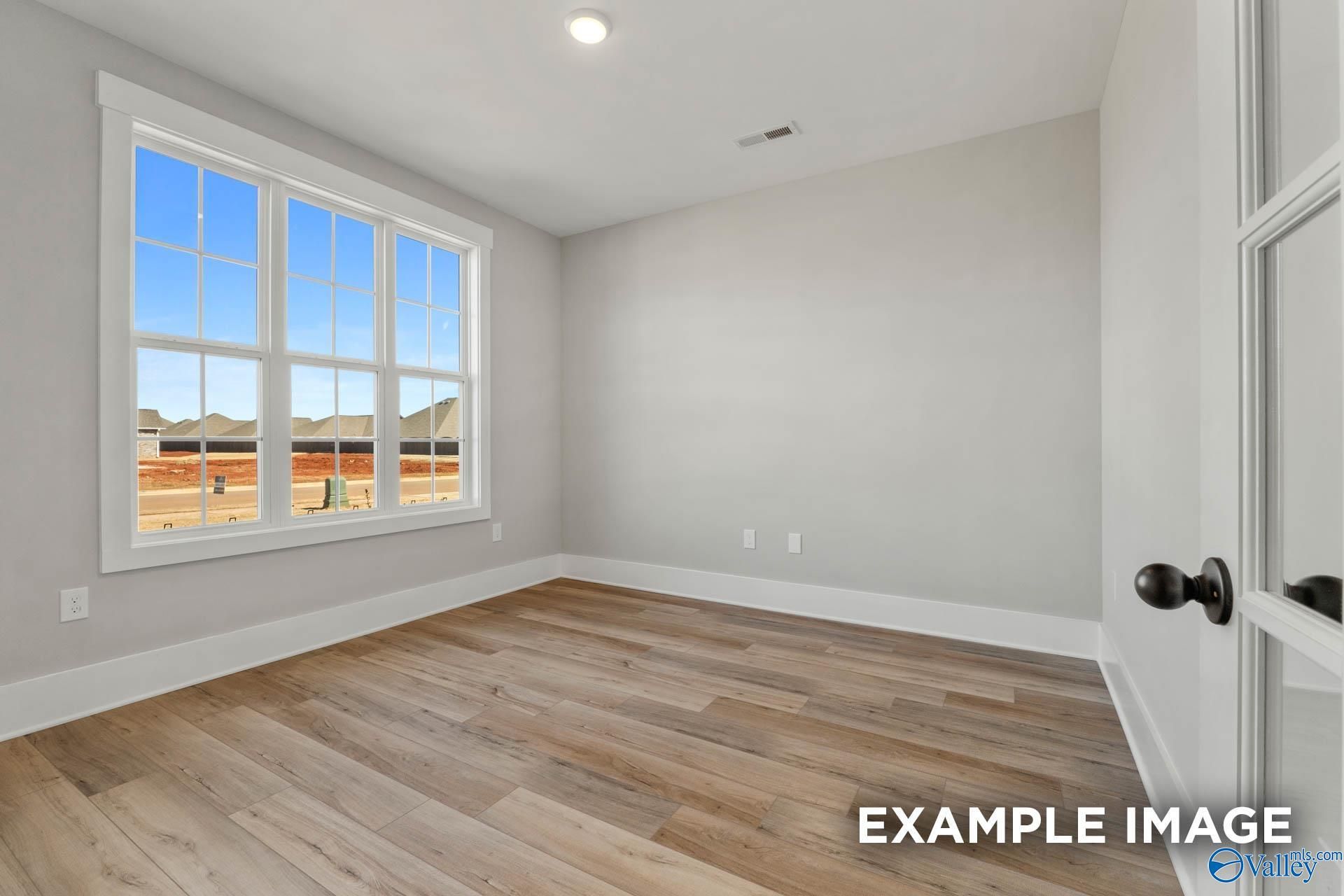 Bright home office or bedroom with wood-look flooring in The Finleigh floor plan by Davidson Homes in Briercreek.