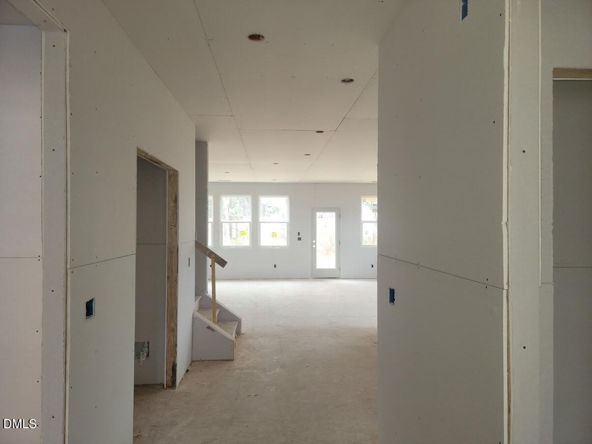 Unfinished open hallway with drywall walls, large windows, stairs, and recessed lights in Davidson Homes Ashport G, Angier, NC