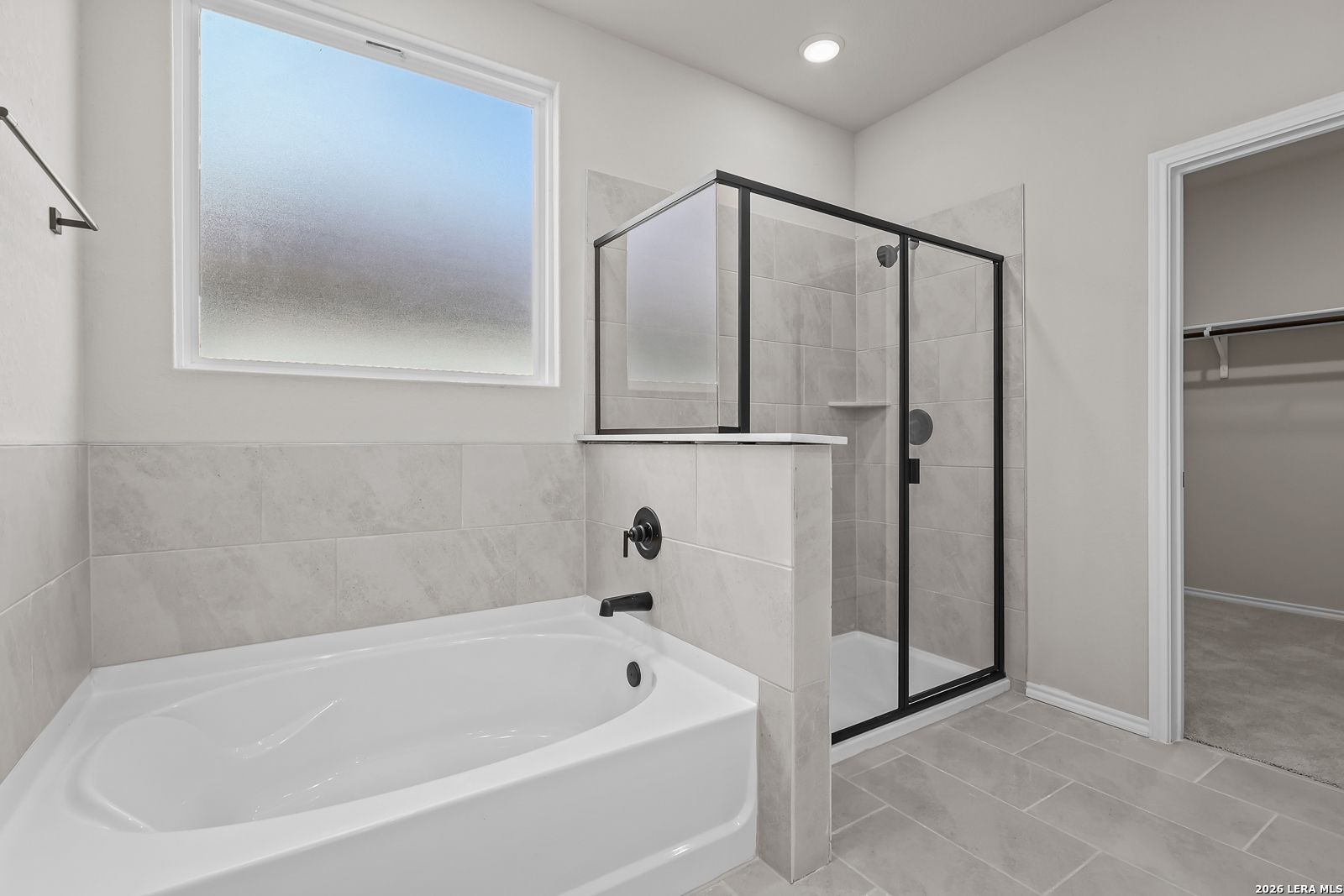 Modern master bathroom with soaking tub, glass walk-in shower, and frosted window in Davidson Homes The Sequoia C, San Antonio