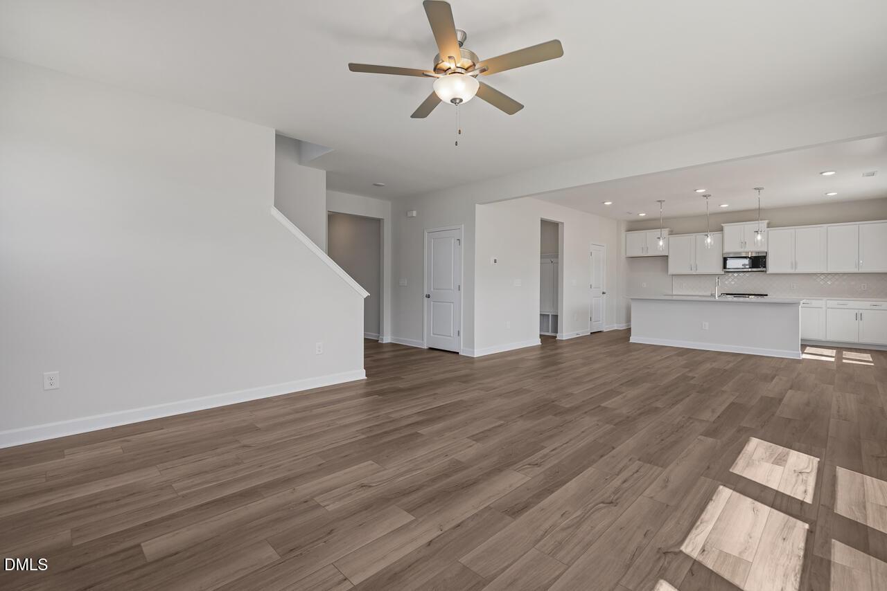 Open-concept living room and kitchen with wood-look flooring at The Chestnut B in Retreat at North Main, Lillington, NC.