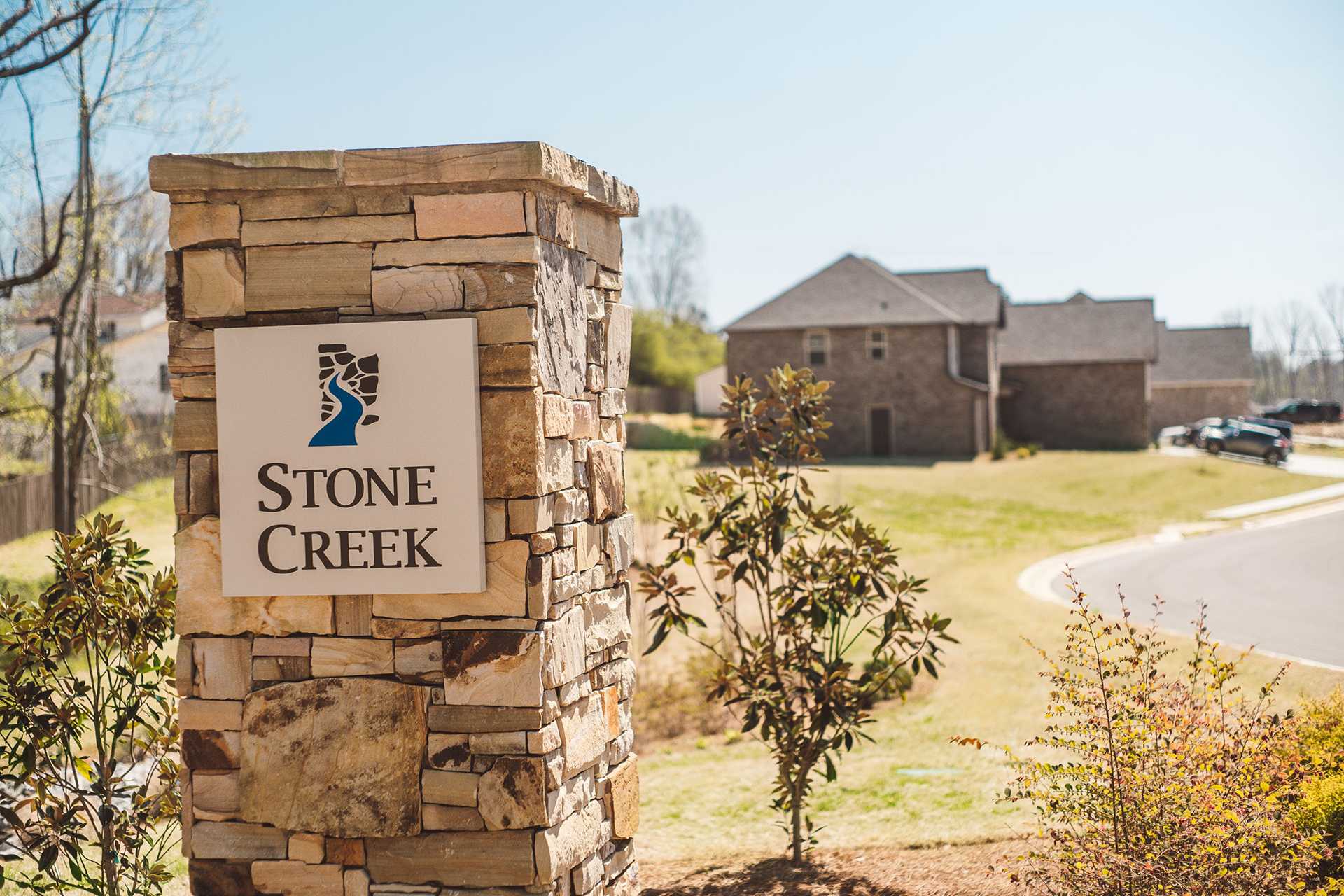 Stone Creek Phase II entrance sign with stone pillars, lush landscaping, and new homes in Cullman Alabama