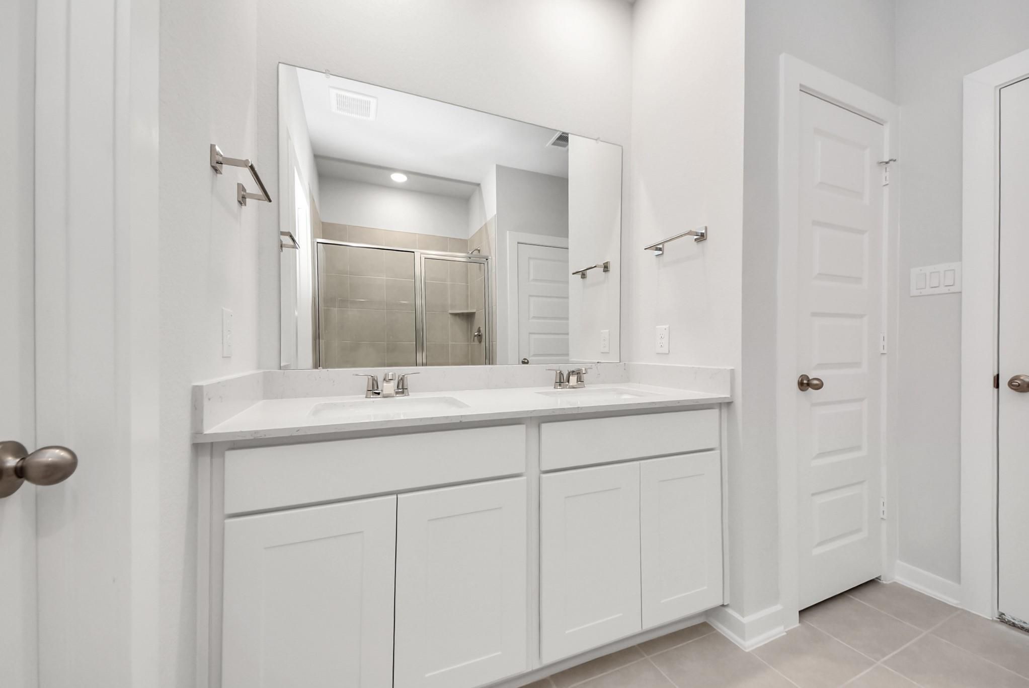 Modern dual vanity with white cabinets and quartz countertops in The Blanco E floor plan at The Villages at WestPointe.