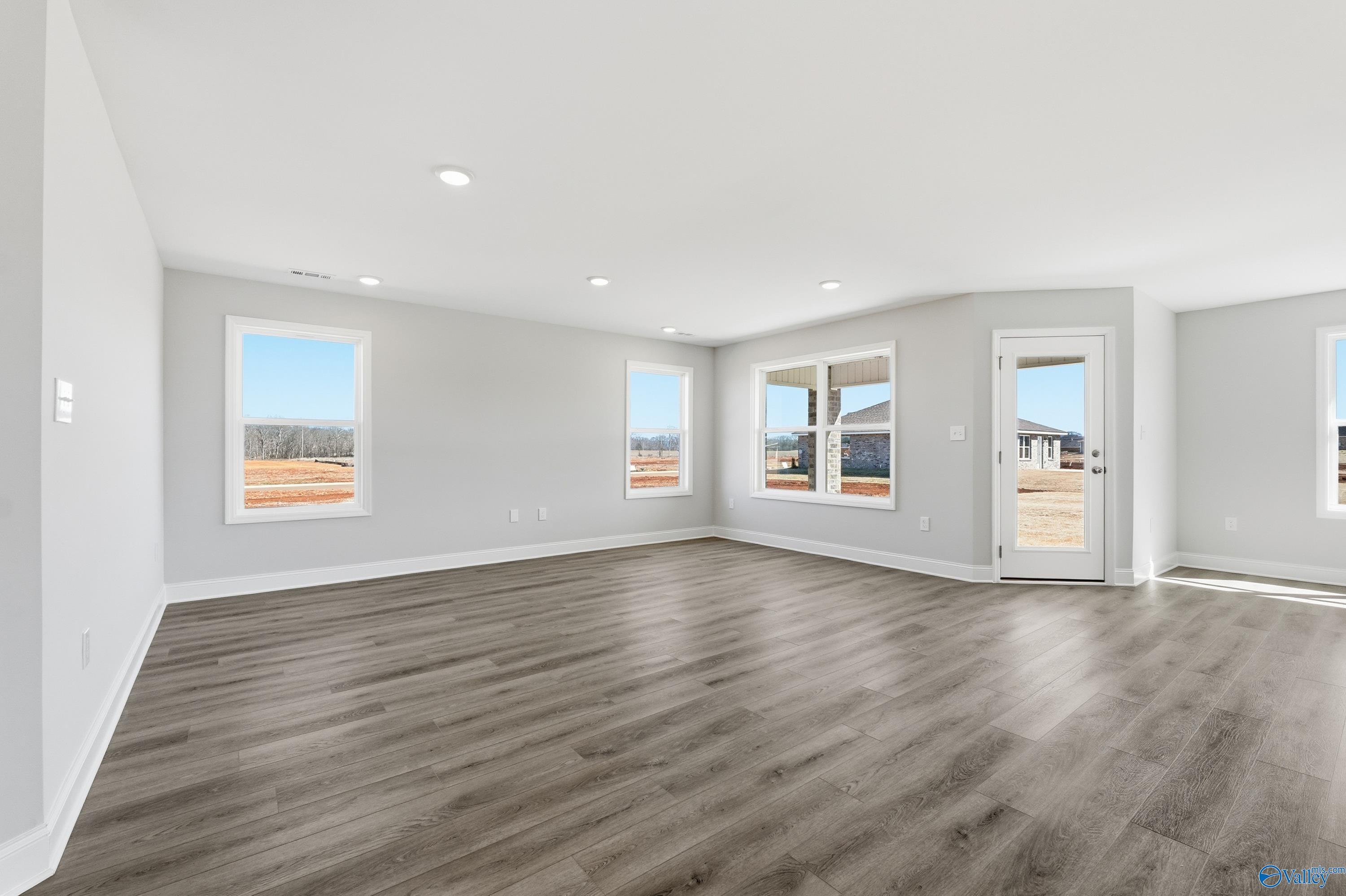 Spacious living room with gray walls, hardwood floors, large windows in Davidson Homes The Franklin, New Market, Alabama