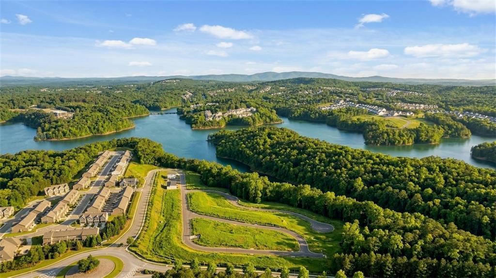 Aerial view of The Bluffs community in Canton, Georgia, with Davidson Homes townhomes along lush lakeside forests and rolling hills