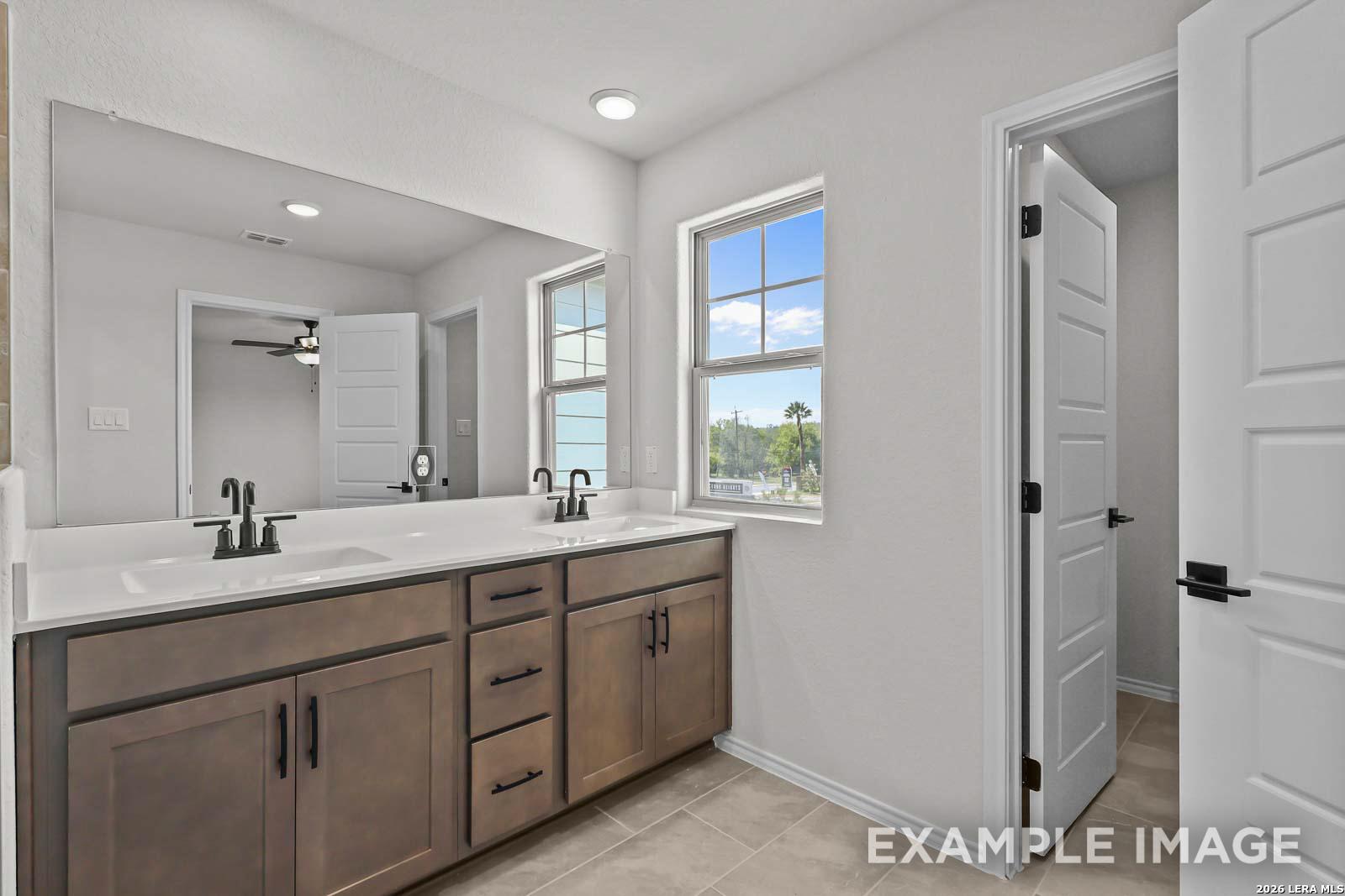 Modern bathroom with dual vanity and large mirror in The Florence D floor plan by Davidson Homes, Cedar Heights, San Antonio.