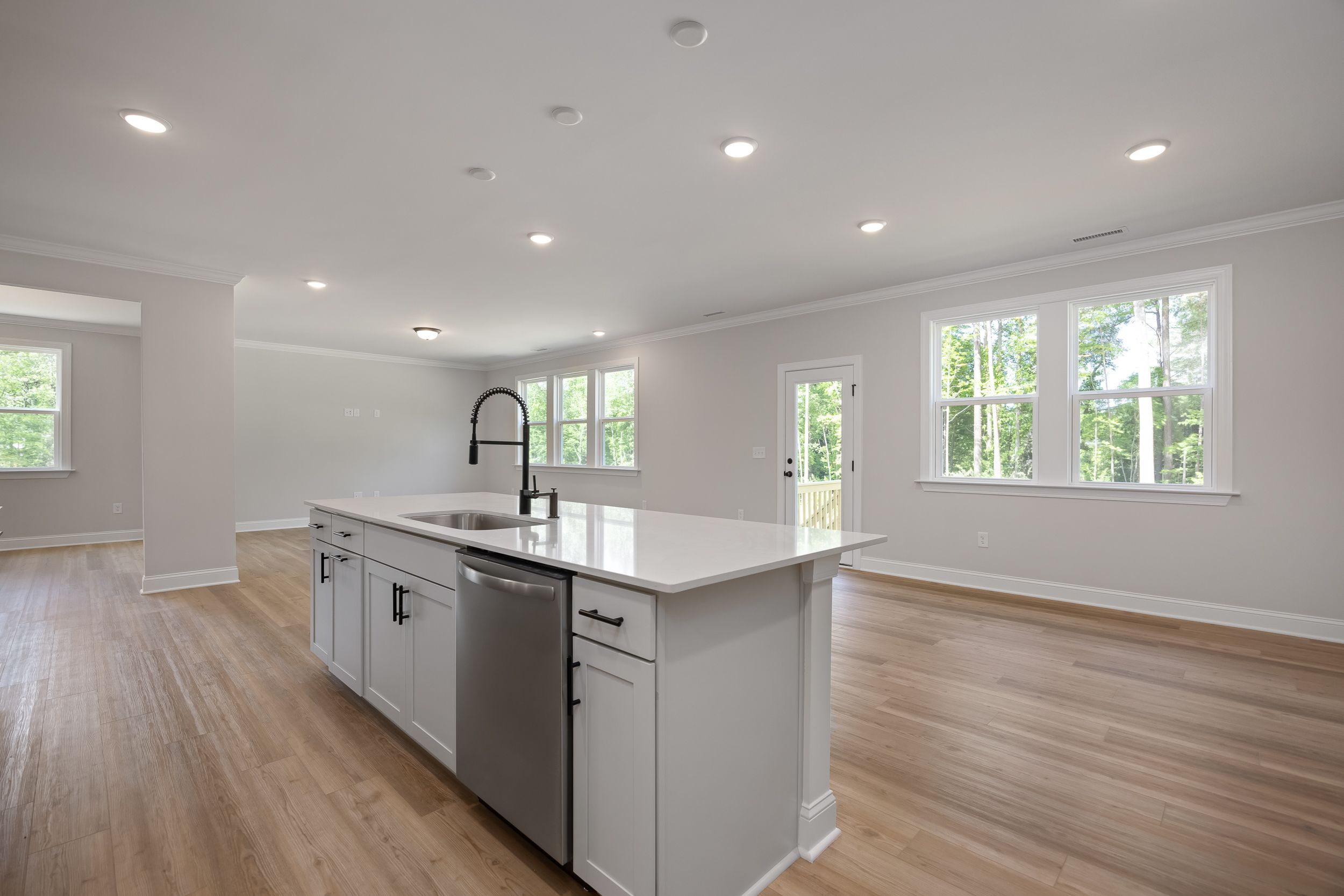 Spacious kitchen in The Beech A by Davidson Homes: white quartz island, black faucet, open layout, large windows, hardwood floors
