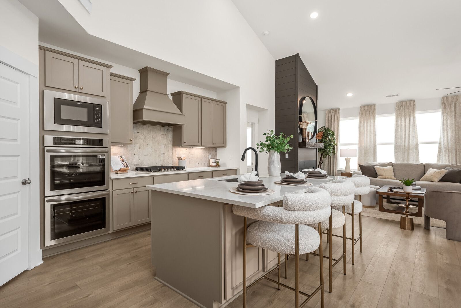 Modern open-concept kitchen and living room at Benders Cove in Mt. Juliet TN with gray island, double oven, and hardwood floors