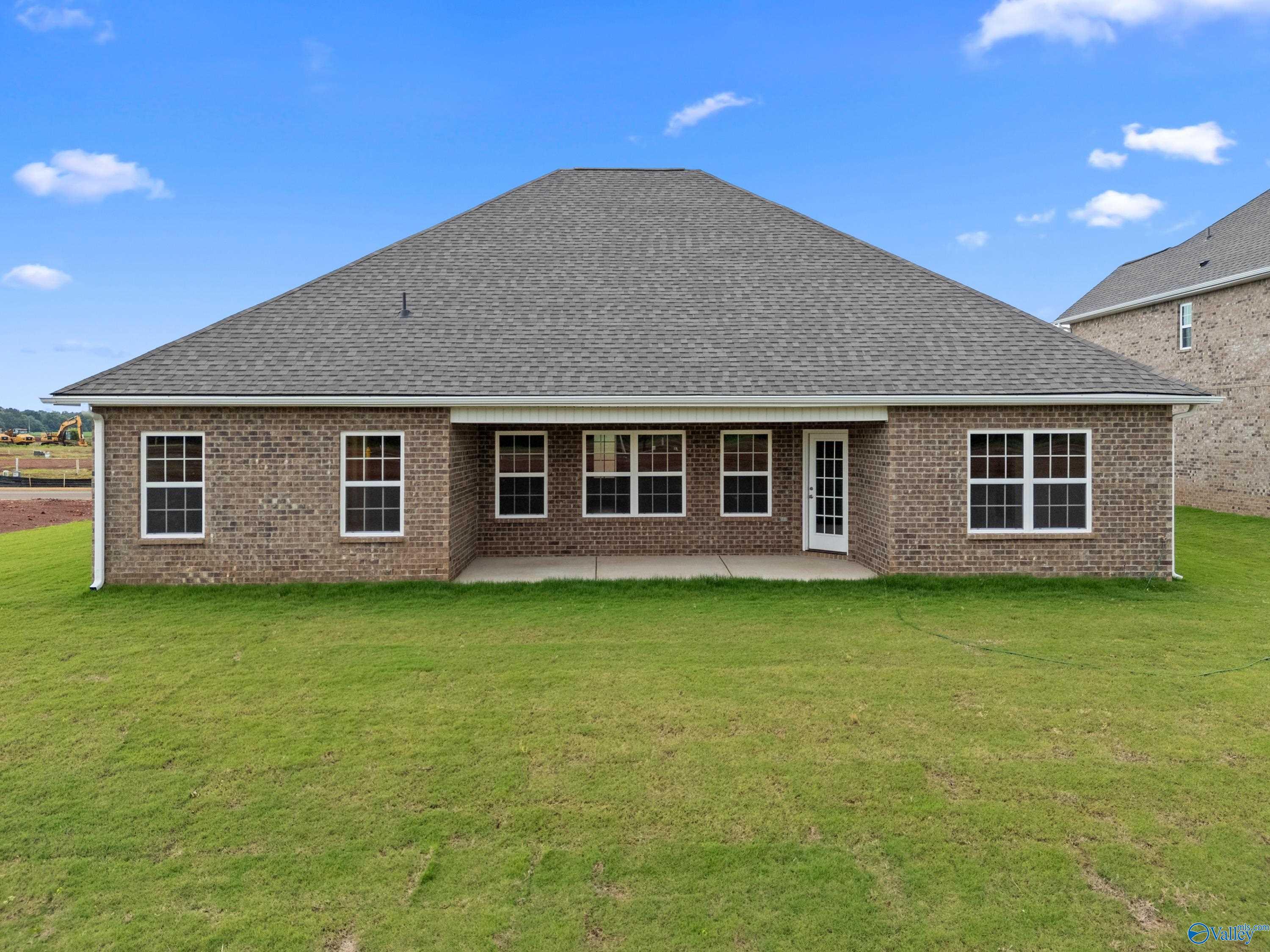 Brick home exterior with covered patio, French doors, and green lawn in Davidson Homes The Rockford B, Kendall Farms, Toney, Alabama