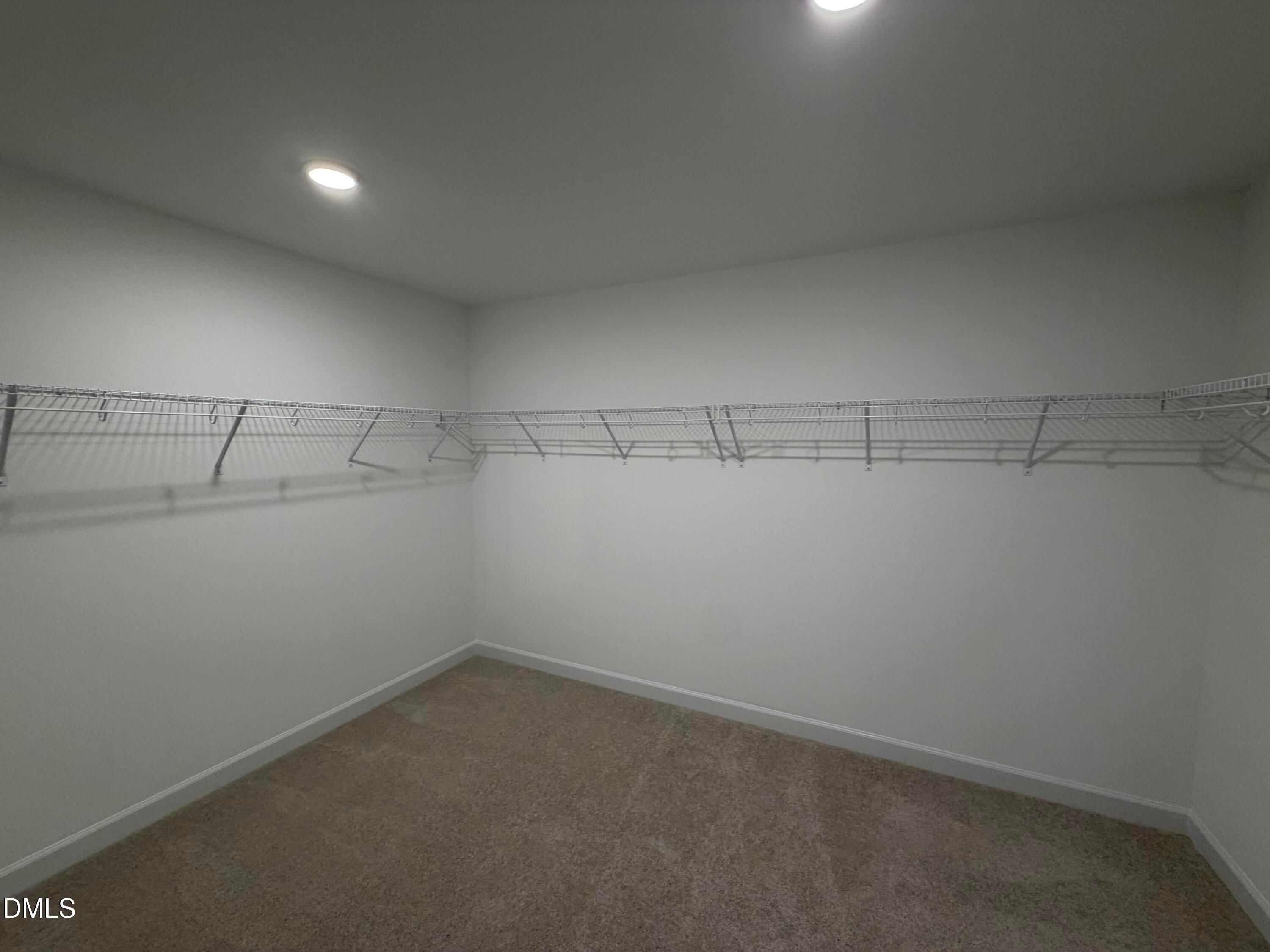 Spacious walk-in closet with wire shelving and carpet flooring in Davidson Homes The Preston C, Wendell Ridge, North Carolina