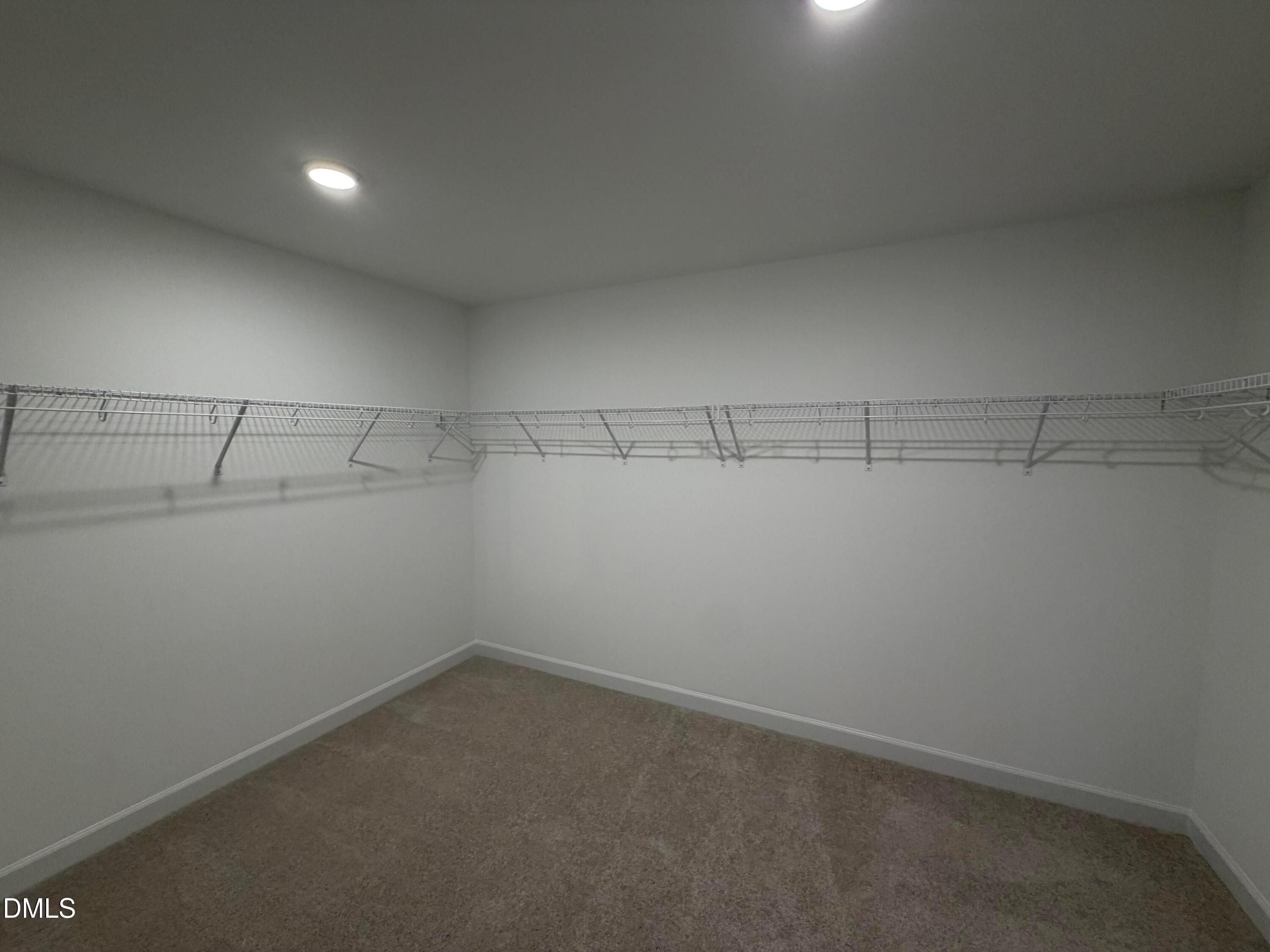 Spacious walk-in closet with wire shelving and carpet flooring in Davidson Homes The Preston C, Wendell Ridge, North Carolina