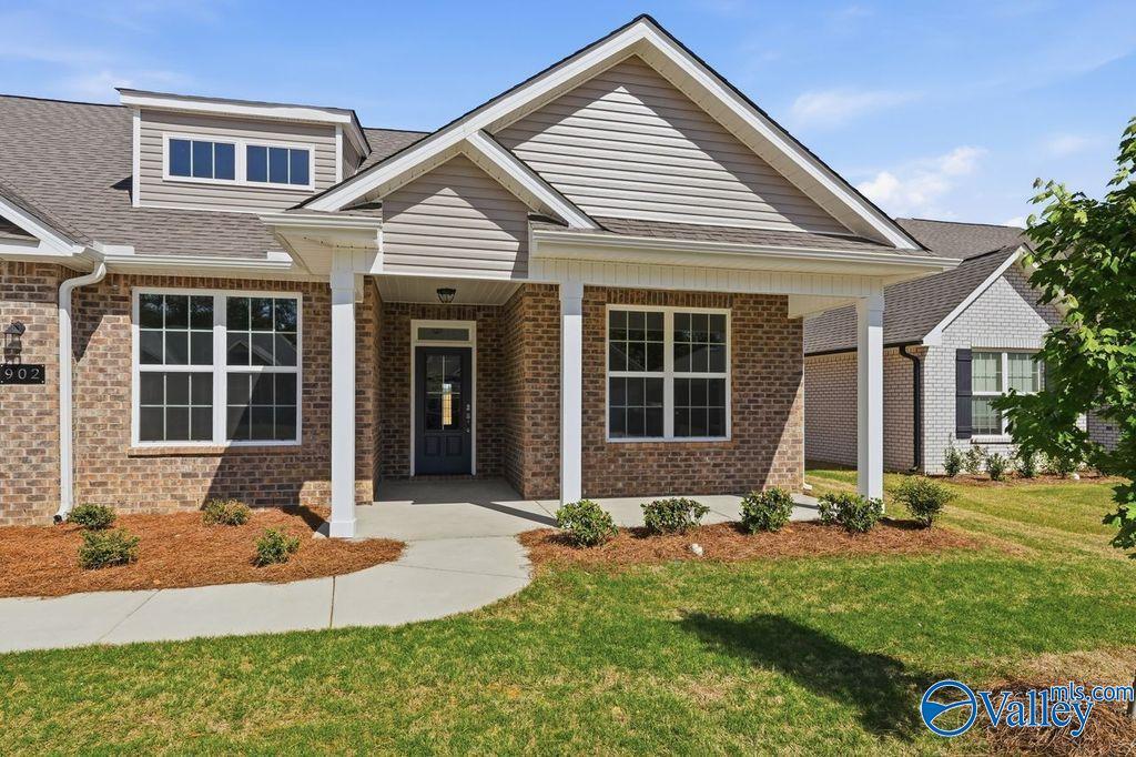 Front exterior of The Harrison 4-bedroom brick home by Davidson Homes in Cain Park, Hartselle, Alabama, with covered porch and landscaped yard