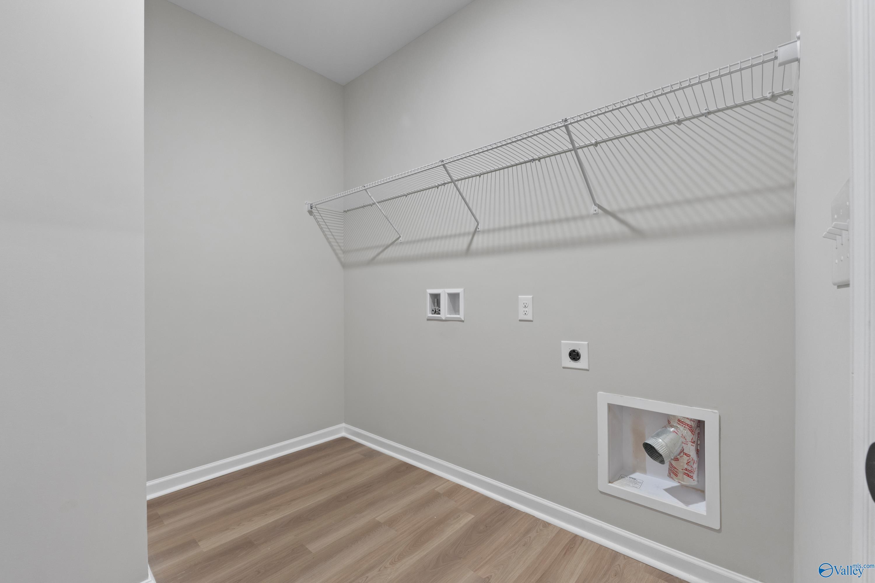 Spacious laundry room with wire shelving, washer/dryer hookups and gray walls in Davidson Homes The Phoenix, Fayetteville, TN