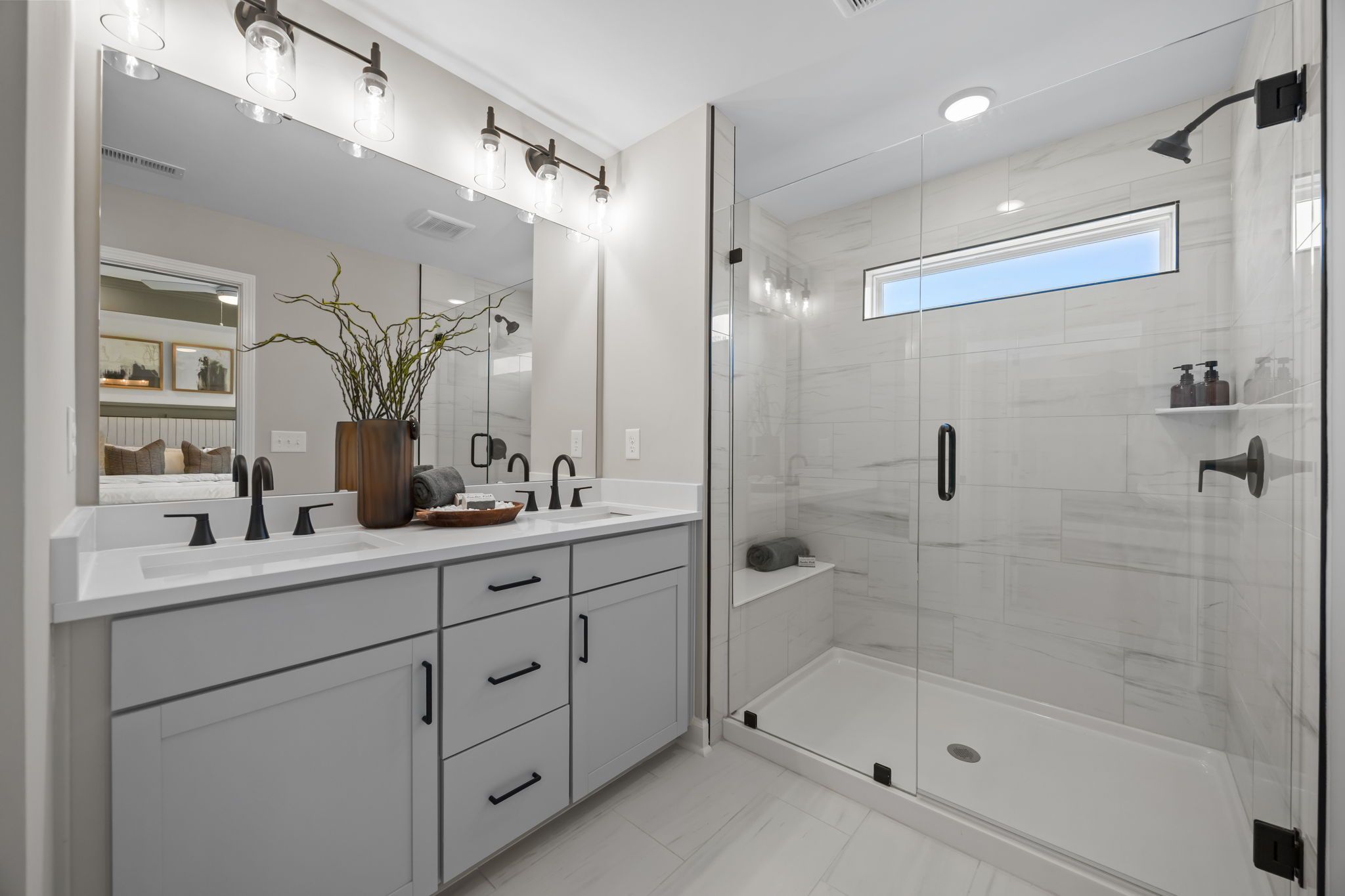 Spacious primary bathroom at Camden Park in Knightdale NC with double vanity, frameless glass shower, and modern fixtures