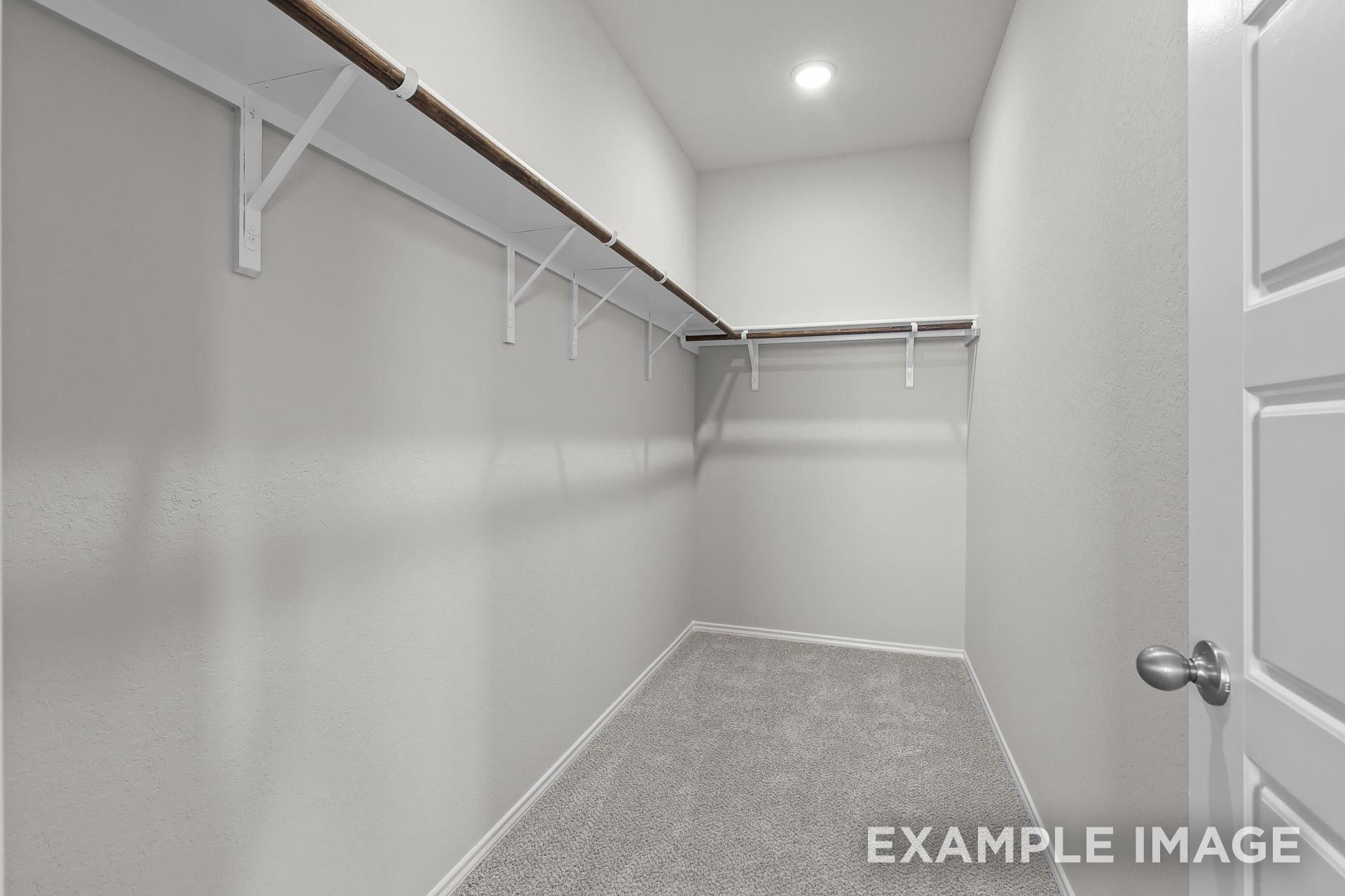 Walk-in closet with built-in shelving in The Colorado G floor plan by Davidson Homes in Heartland, Texas.