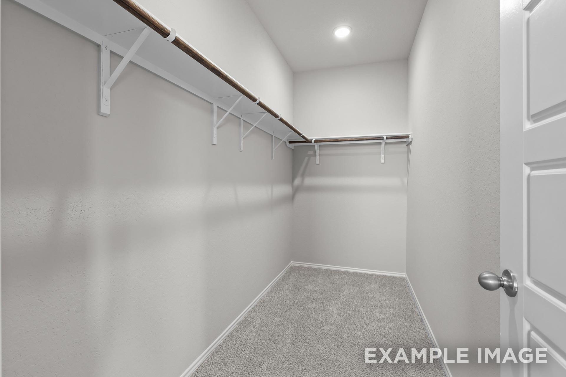 Walk-in closet with built-in shelving in The Colorado G floor plan by Davidson Homes in Heartland, Texas.
