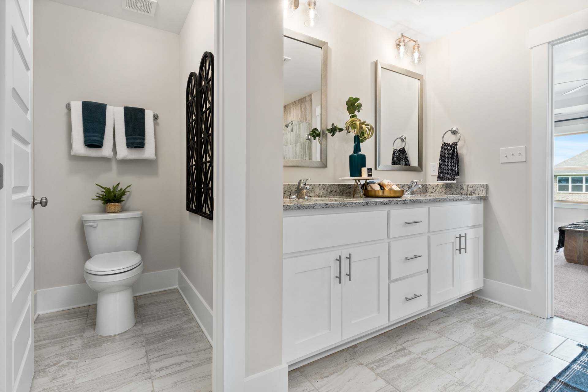 Spacious primary bathroom at Walker's Hill in Meridianville AL with double vanity, white shaker cabinets, and luxury tile flooring