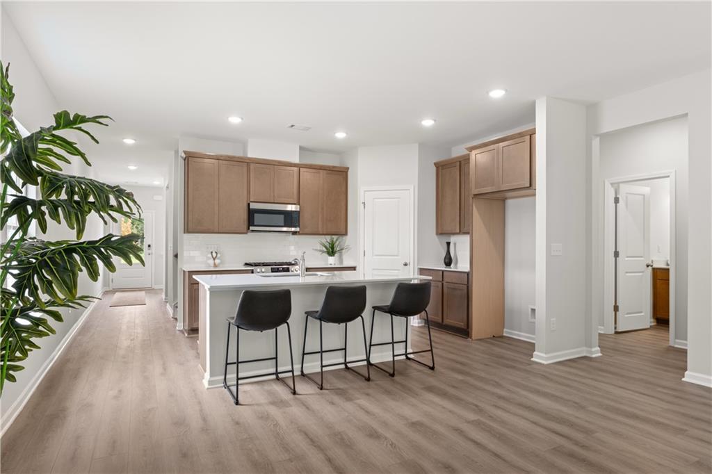 Modern kitchen with island and bar seating in The Sinclair B floor plan at Cedar Farms, Winder, Georgia.