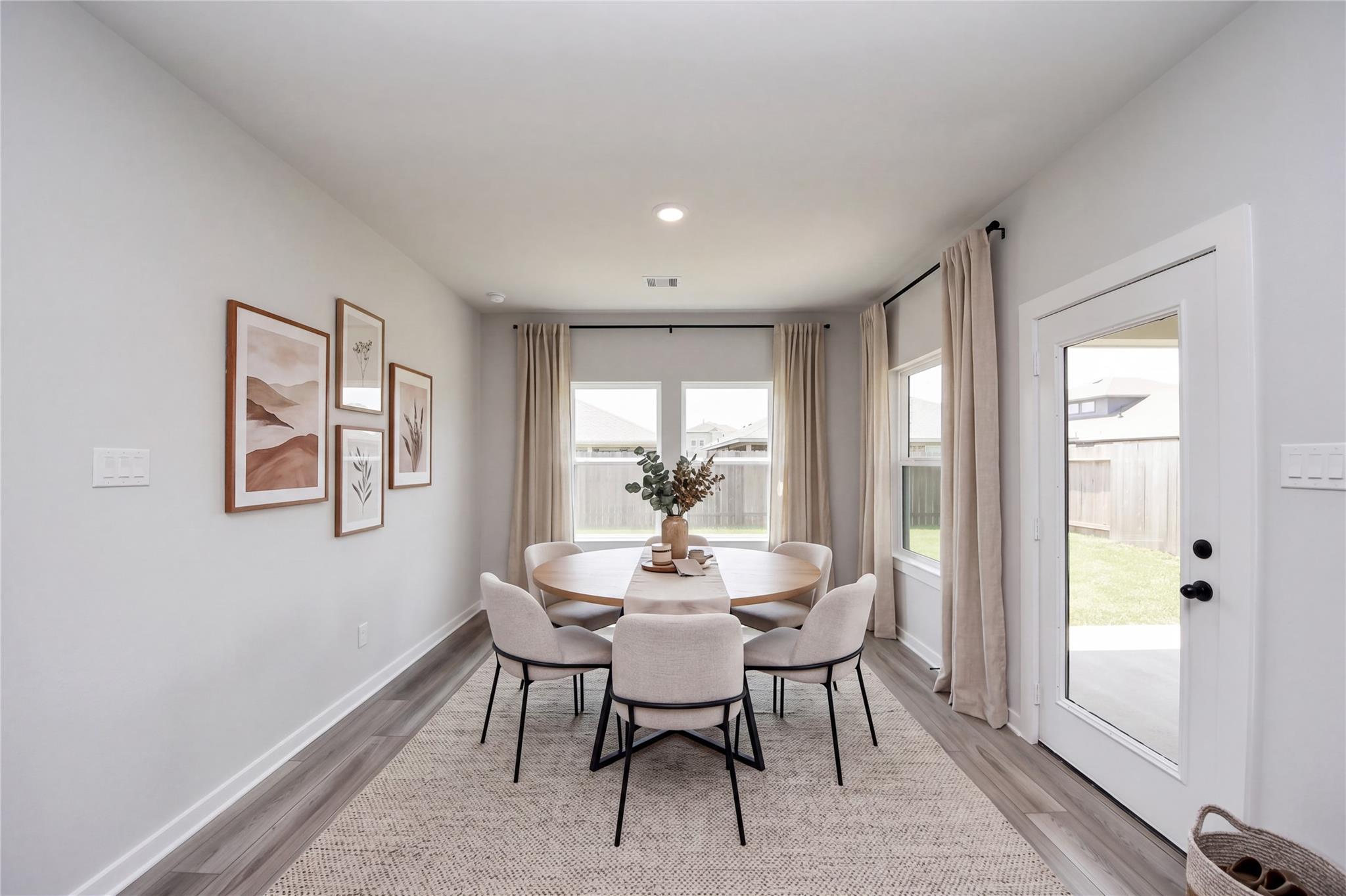 Bright dining area with modern table and chairs in The Everett C floor plan at River Ranch Meadows in Dayton, Texas.