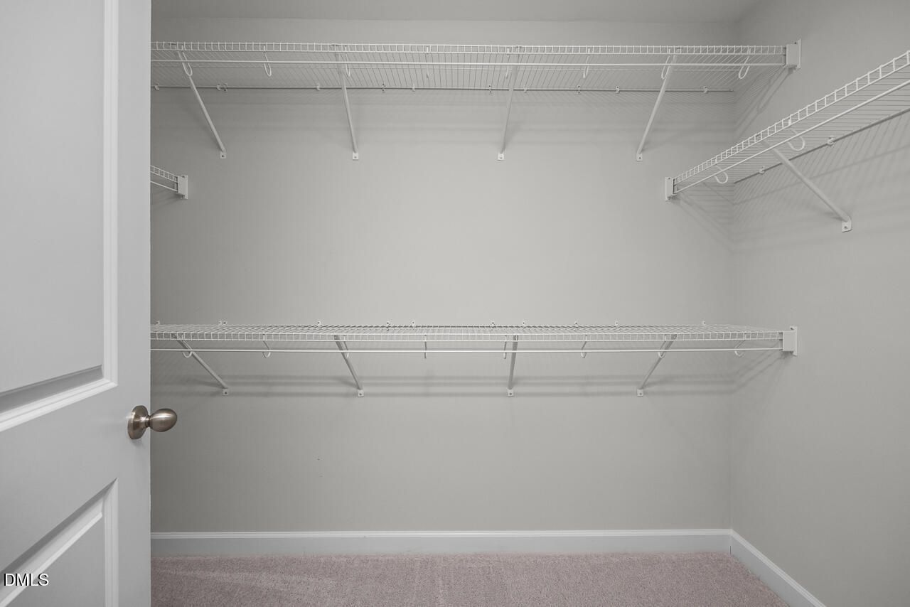 Walk-in closet with white wire shelving in The Grace C floor plan at Retreat at North Main, Lillington, North Carolina.