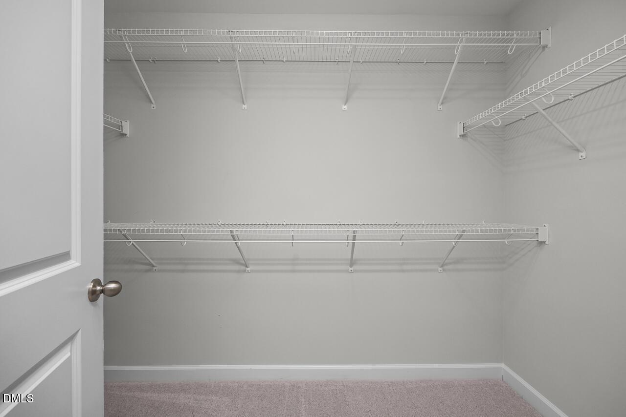 Walk-in closet with white wire shelving in The Grace C floor plan at Retreat at North Main, Lillington, North Carolina.