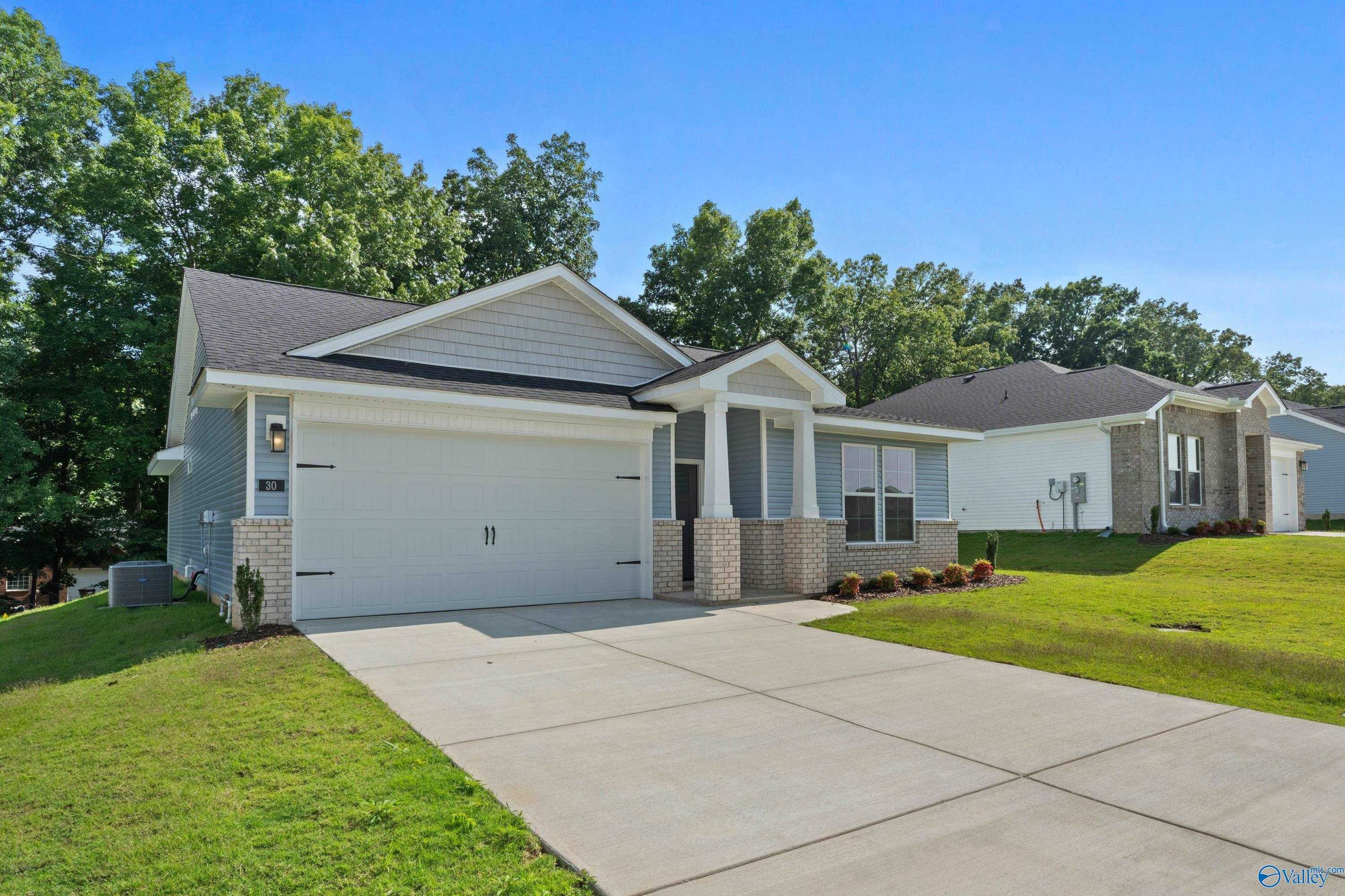 Modern single-story 3-bedroom home with white siding, 2-car garage, brick accents, front porch, green lawn in Bailey Park, Fayetteville, Tennessee
