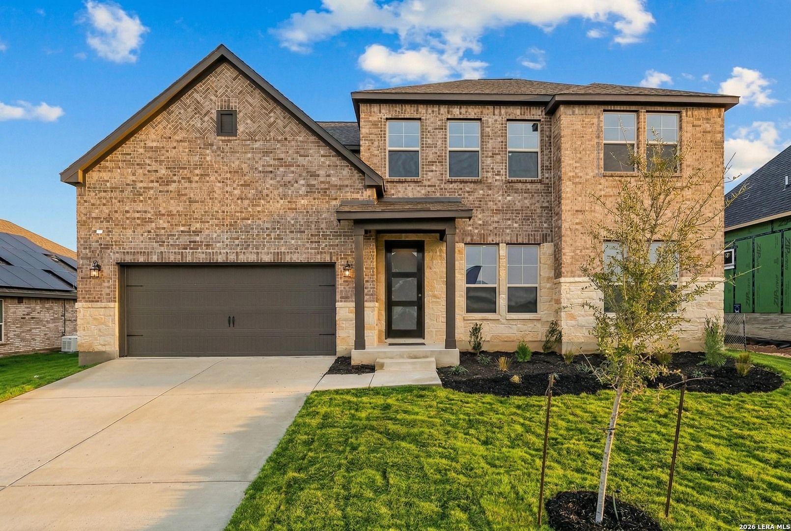 Two-story brick and stone home, The Belmont G floor plan, by Davidson Homes in The Reserve at Potranco Oaks, Castroville, TX.