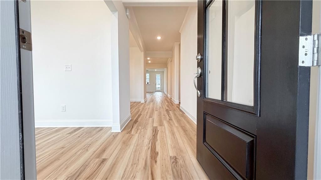 Bright foyer entrance with wood-look flooring in The Glenwood A floor plan at Wehunt Meadows in Hoschton, Georgia.