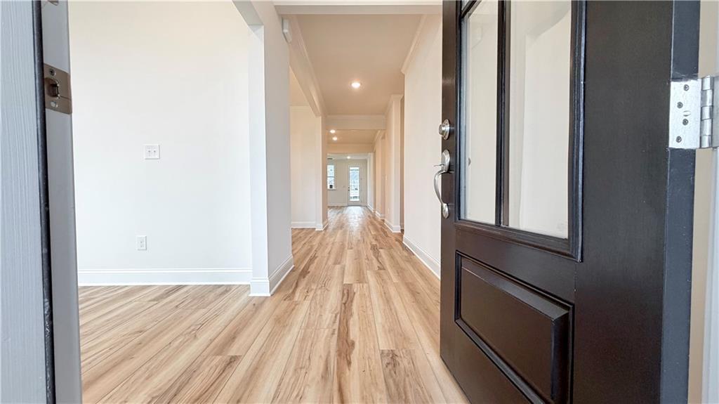 Bright foyer entrance with wood-look flooring in The Glenwood A floor plan at Wehunt Meadows in Hoschton, Georgia.