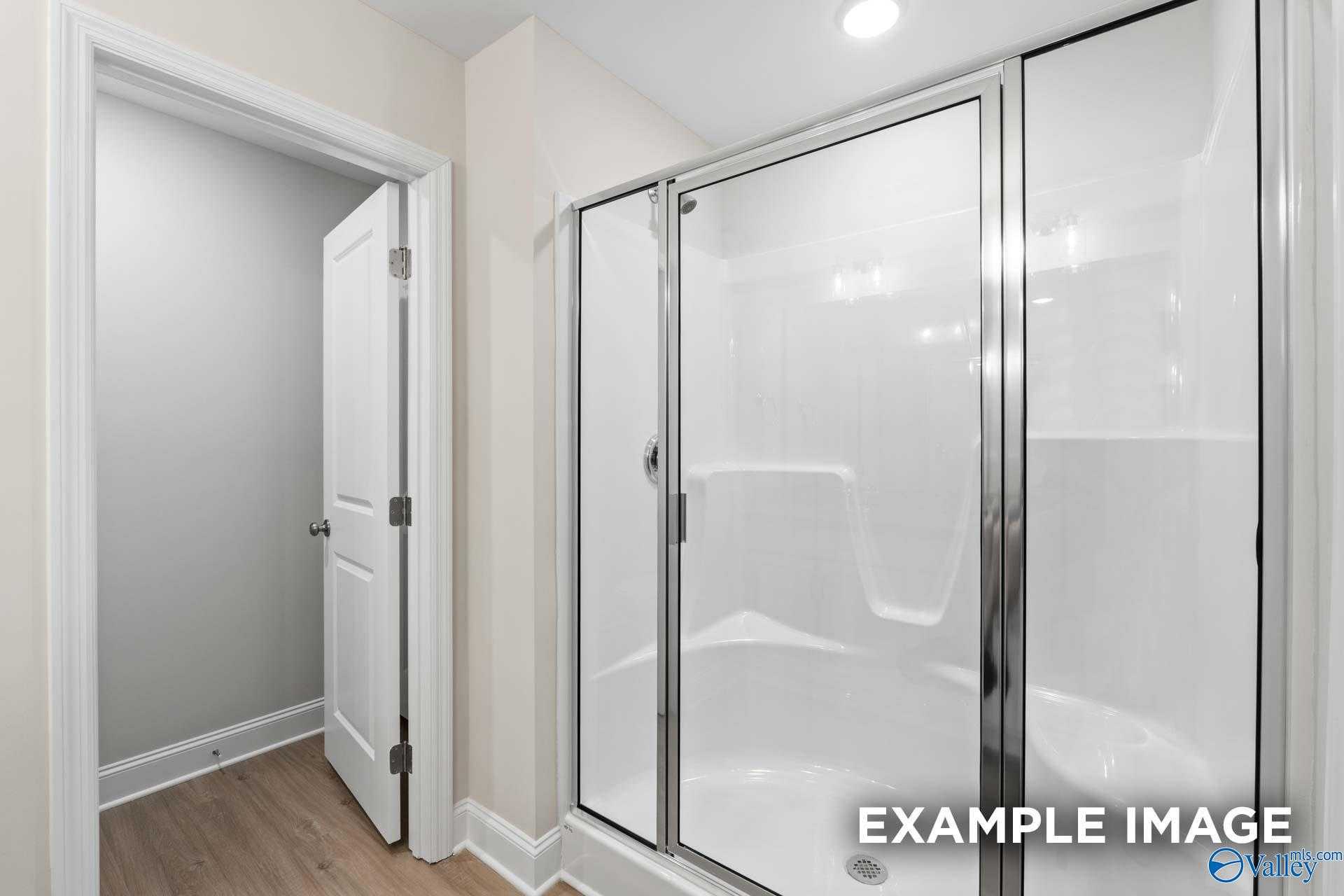 Modern master bathroom with frameless glass shower enclosure and neutral tones in Davidson Homes The Camden C, Huntsville, AL