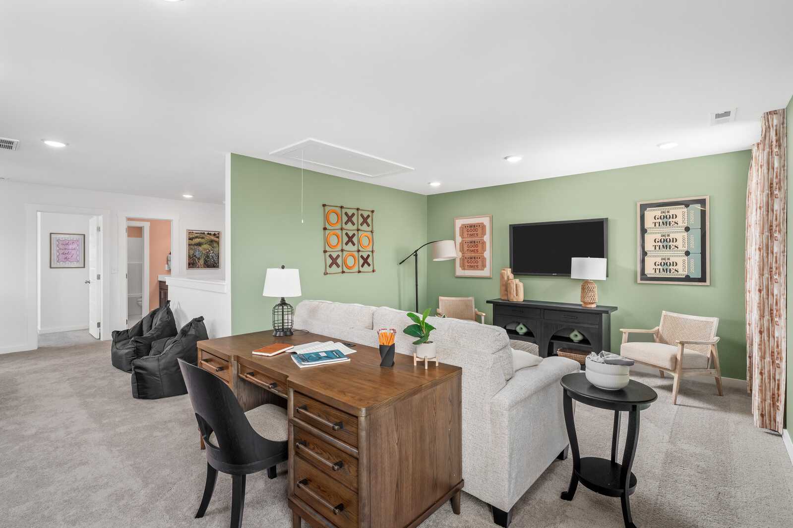 Cozy bonus room at Calista Farms in White House Tennessee with green walls wooden desk sofa and modern artwork