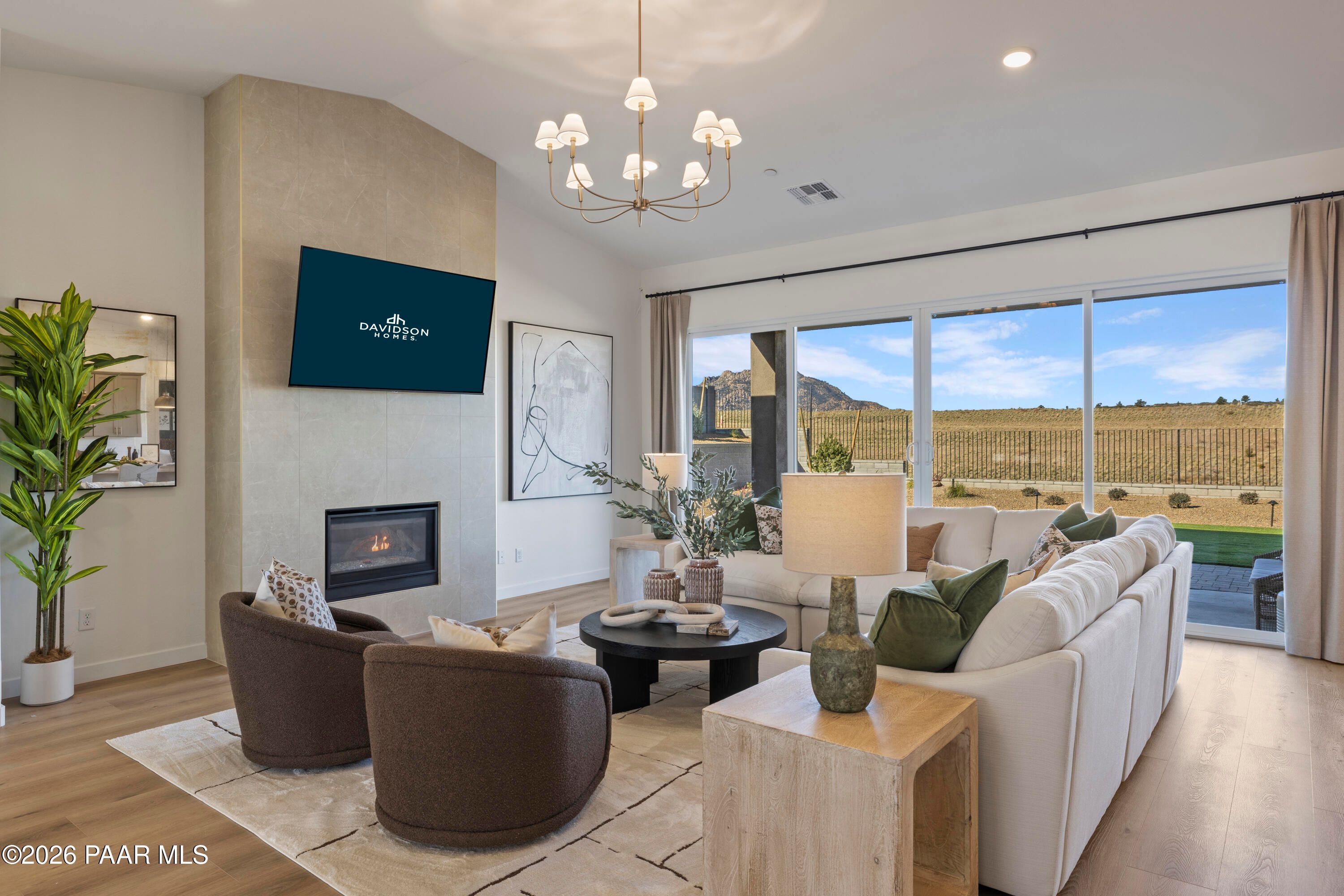 Bright open living room with fireplace and mountain views in The Blaze D floor plan at Hidden Hills, Prescott, Arizona.