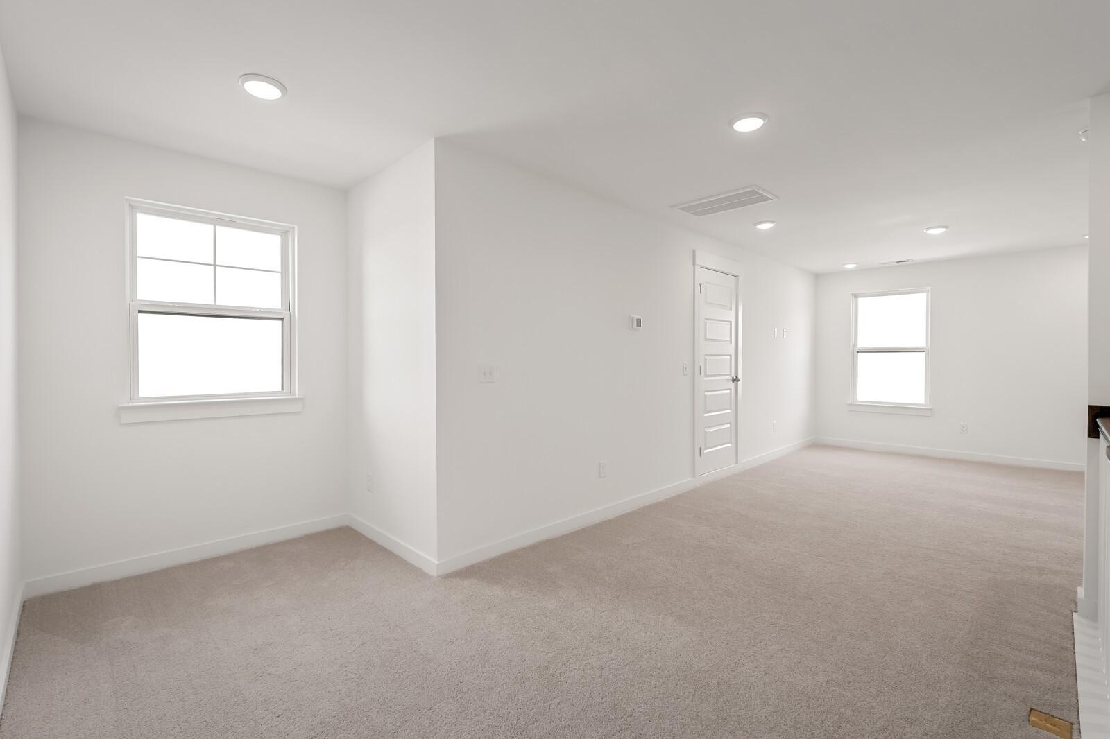Bright upstairs hallway with beige carpet, white walls, large windows, and recessed lighting in Davidson Homes The Ash C, Mt. Juliet, TN