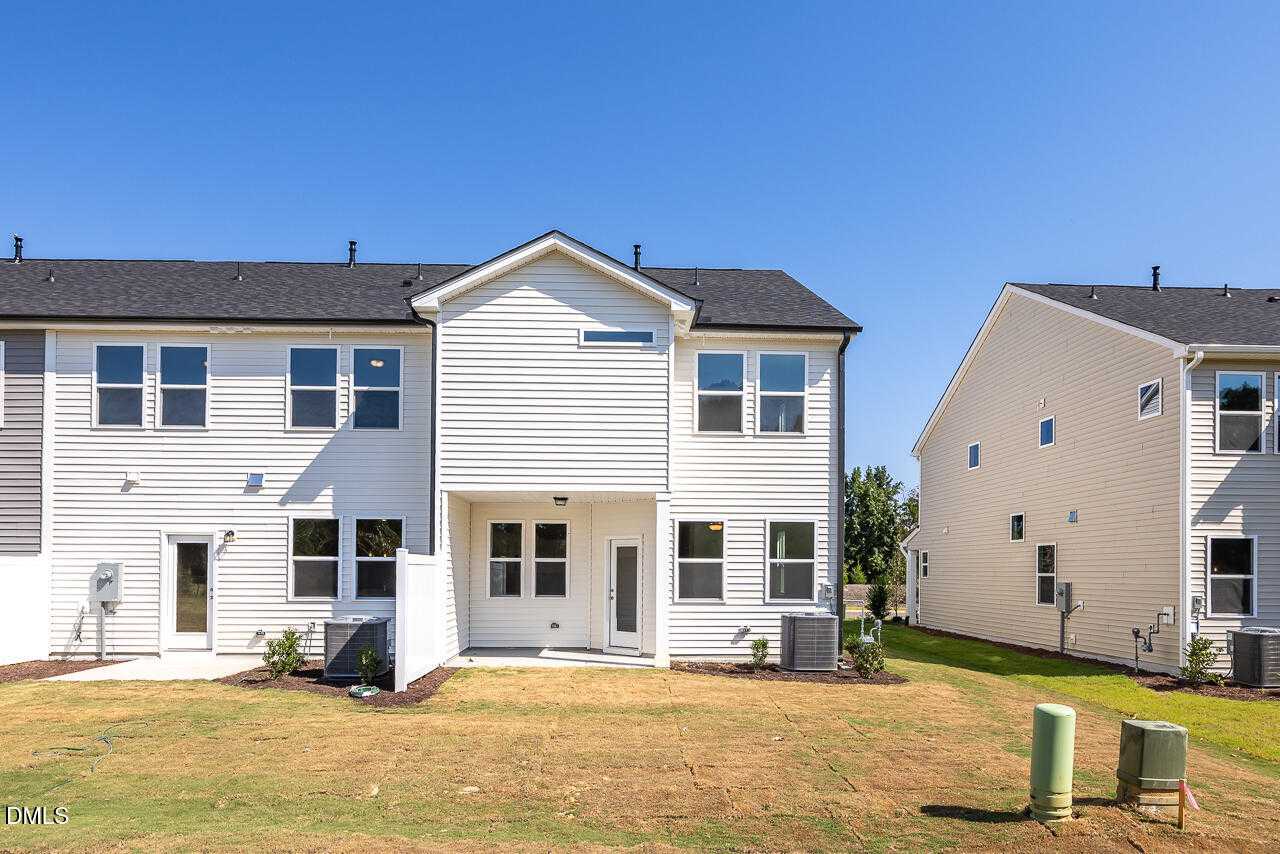 Two-story Graham Exterior home by Davidson Homes with covered back patio and grassy yard in Springvale, Fuquay-Varina, NC