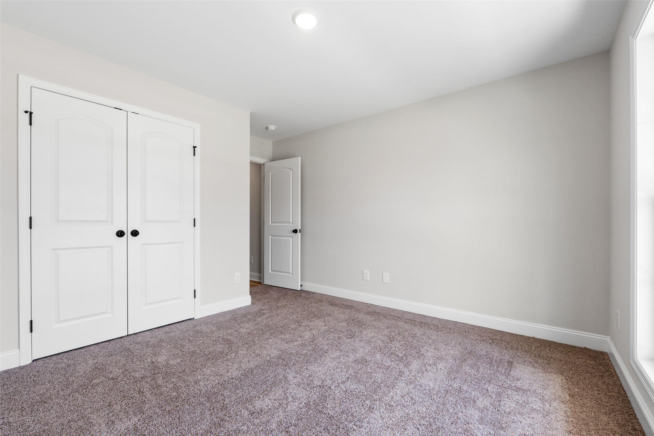 Bright secondary bedroom with plush carpet and closet space in The Holly C floor plan at Parks at Foster Crossing, Anna.