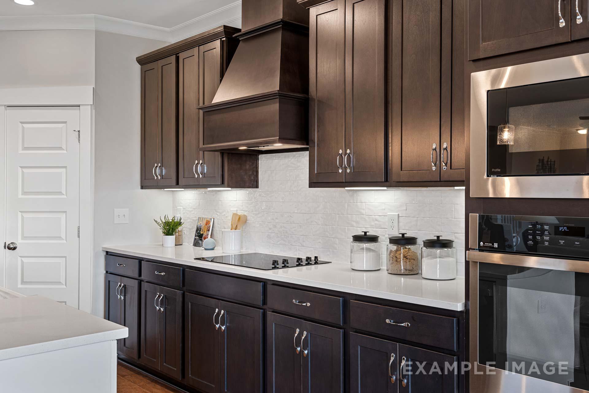 Modern Rockford kitchen by Davidson Homes featuring dark wood cabinets, white quartz island, stainless steel appliances, and subway tile backsplash