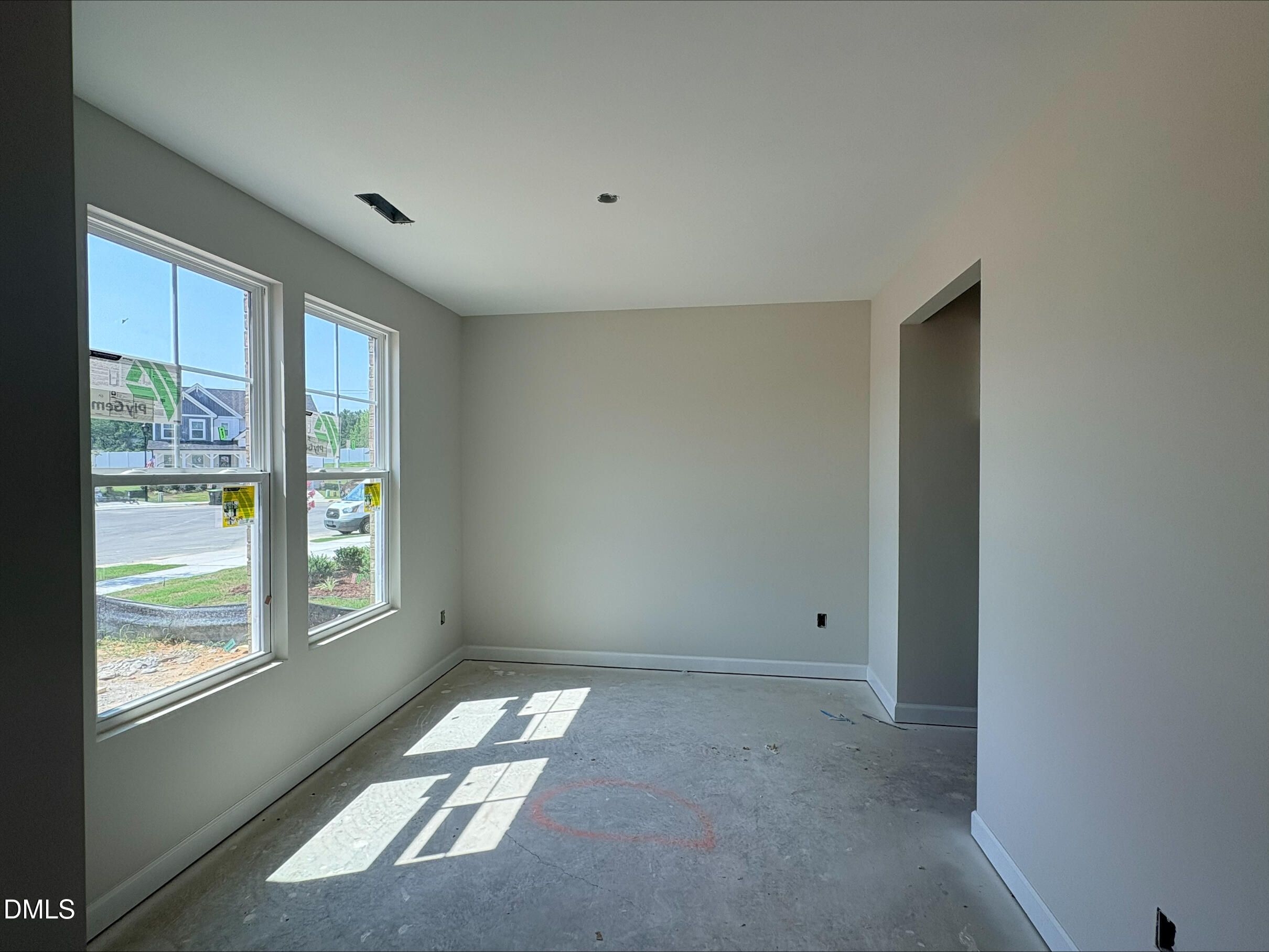 Bright, unfinished bedroom with large windows in The Willow C floor plan at Woodland Crossing, Zebulon, North Carolina.