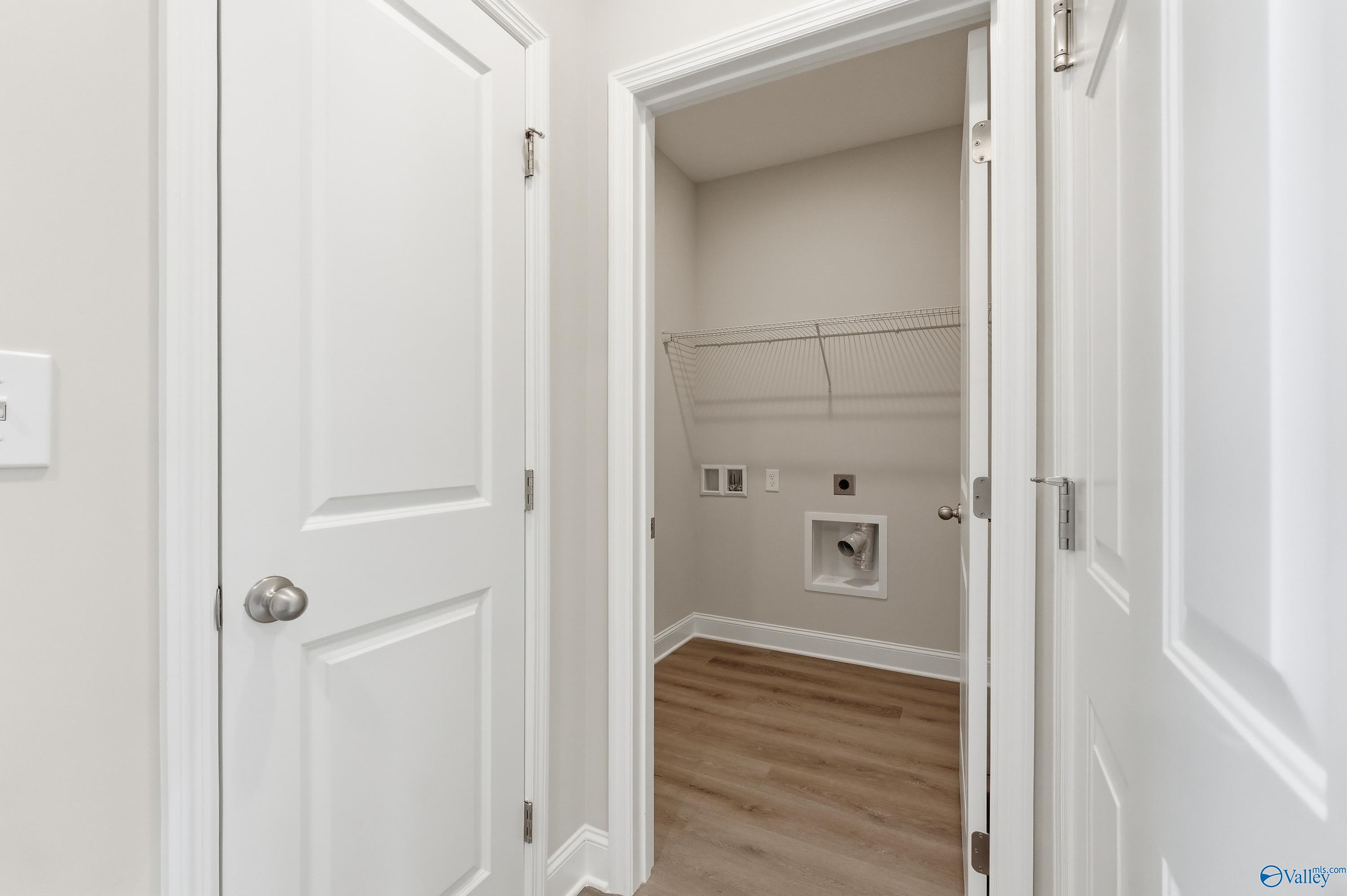 Laundry room with utility sink, washer/dryer hookups, and closet rod in The Asheville C by Davidson Homes, Spragins Cove, Huntsville, AL
