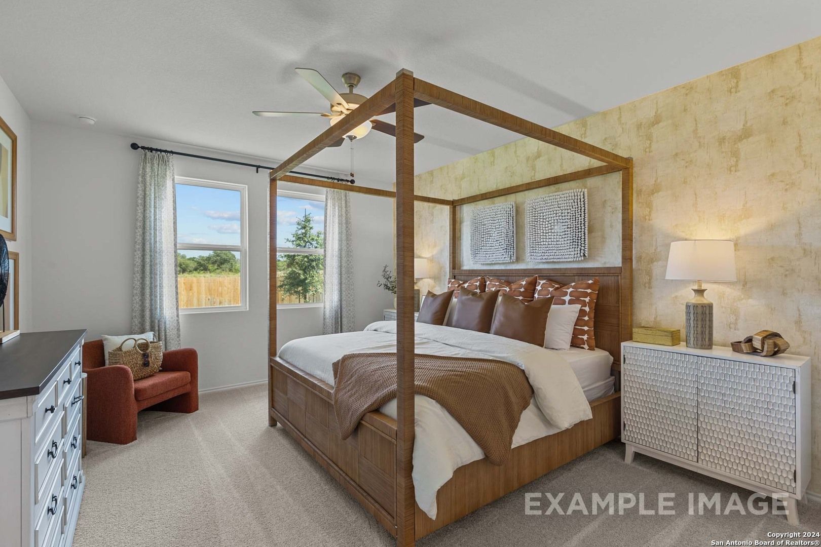 Elegant four-poster bed with plush brown bedding and bedside lamps in master suite of Davidson Homes The Daphne K, San Antonio, Texas