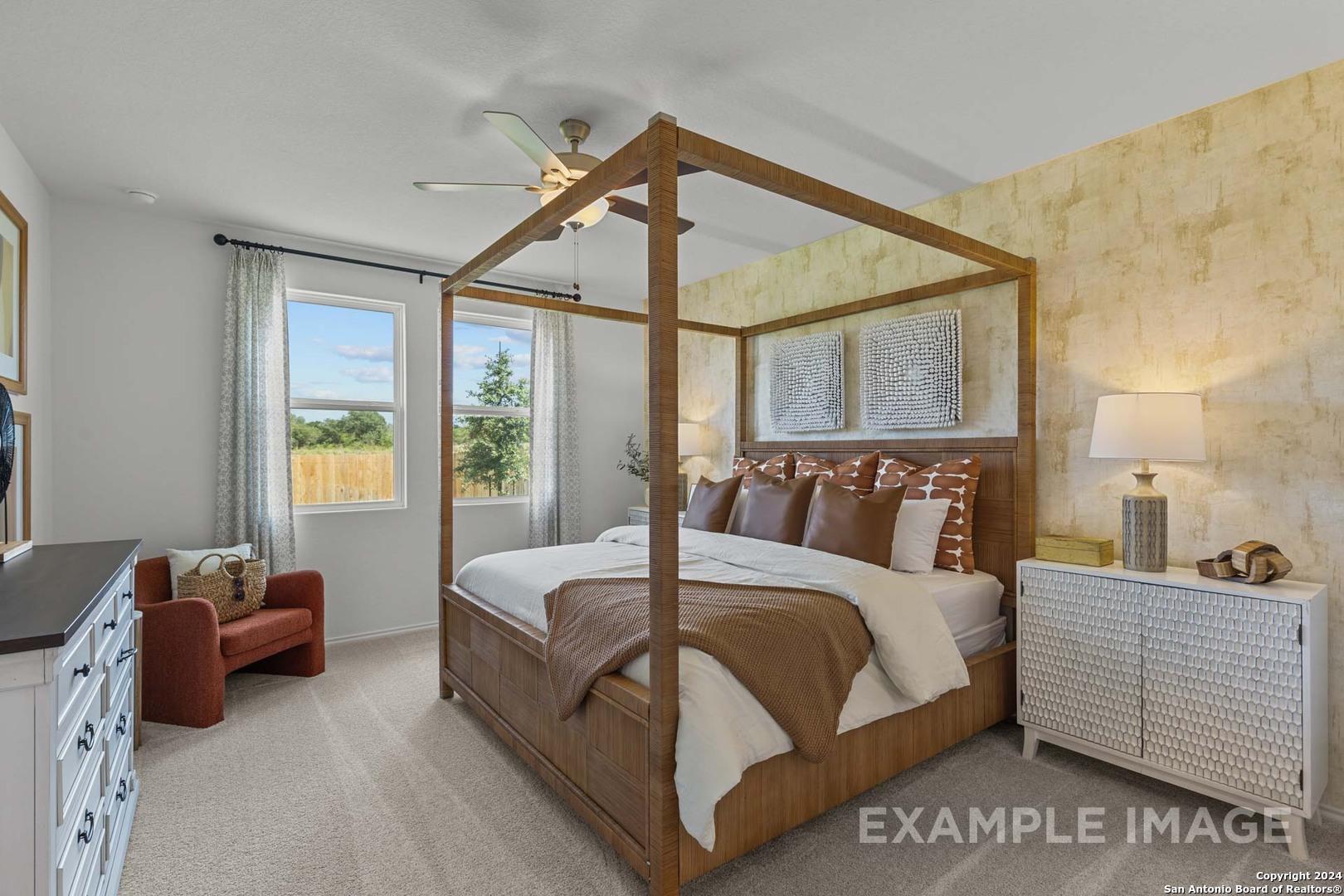 Elegant four-poster bed with plush brown bedding and bedside lamps in master suite of Davidson Homes The Daphne K, San Antonio, Texas