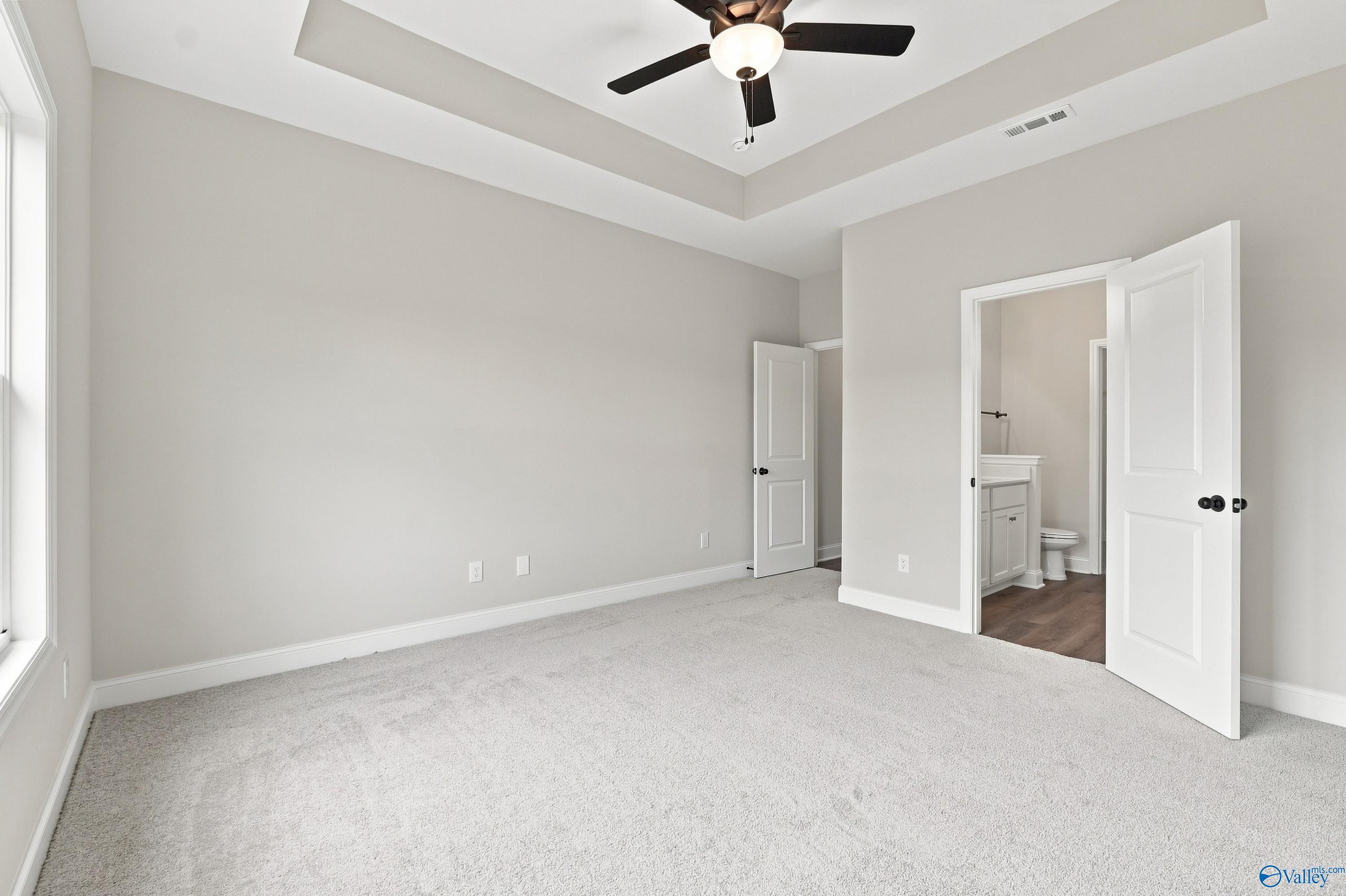 Spacious bedroom with tray ceiling and en-suite bathroom in The Asheville E floor plan by Davidson Homes in Forest Glen.
