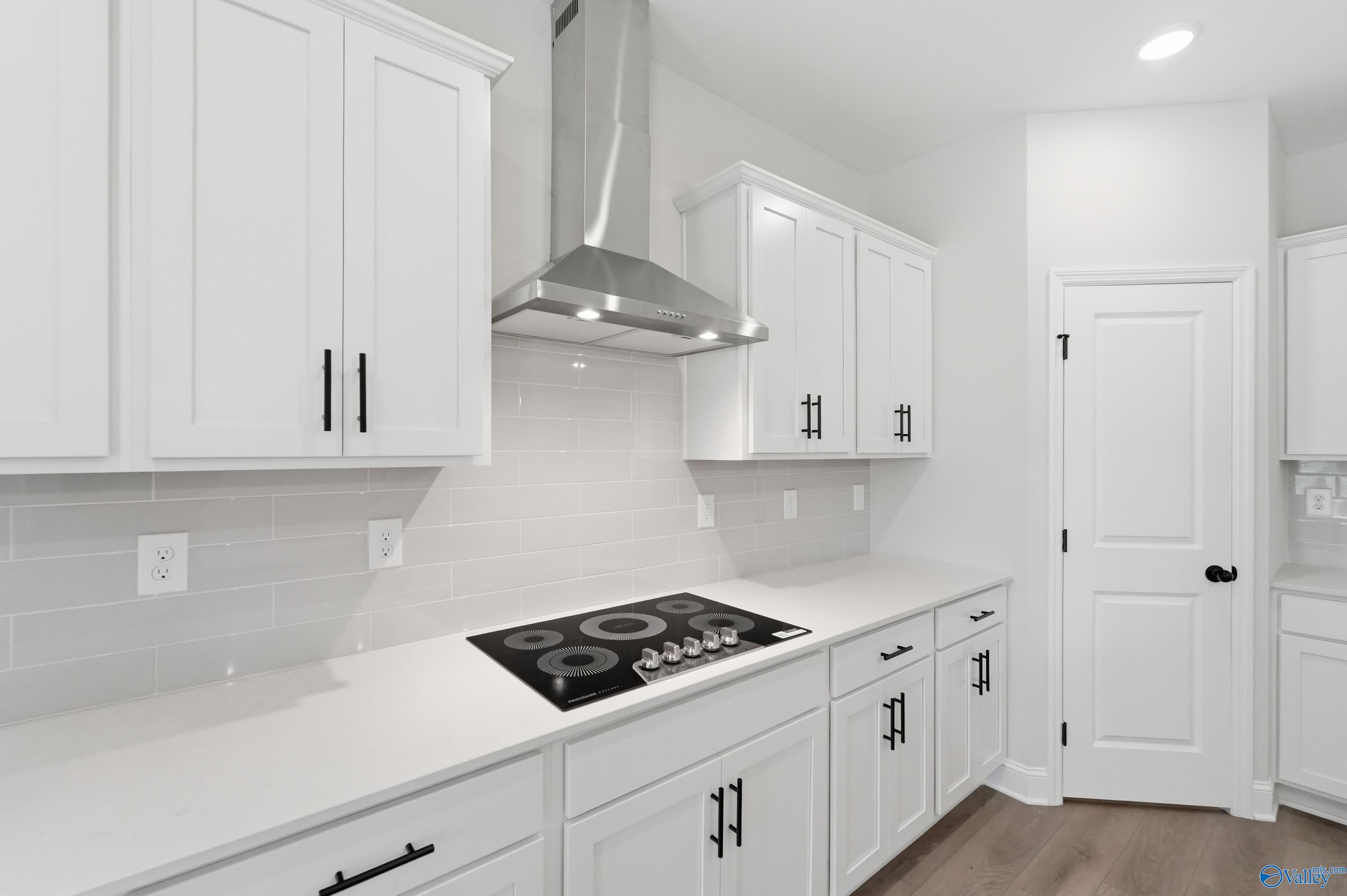 Modern white shaker kitchen featuring stainless range hood, gas cooktop, quartz counters, subway tile in Davidson Homes The Rockford B, Athens AL