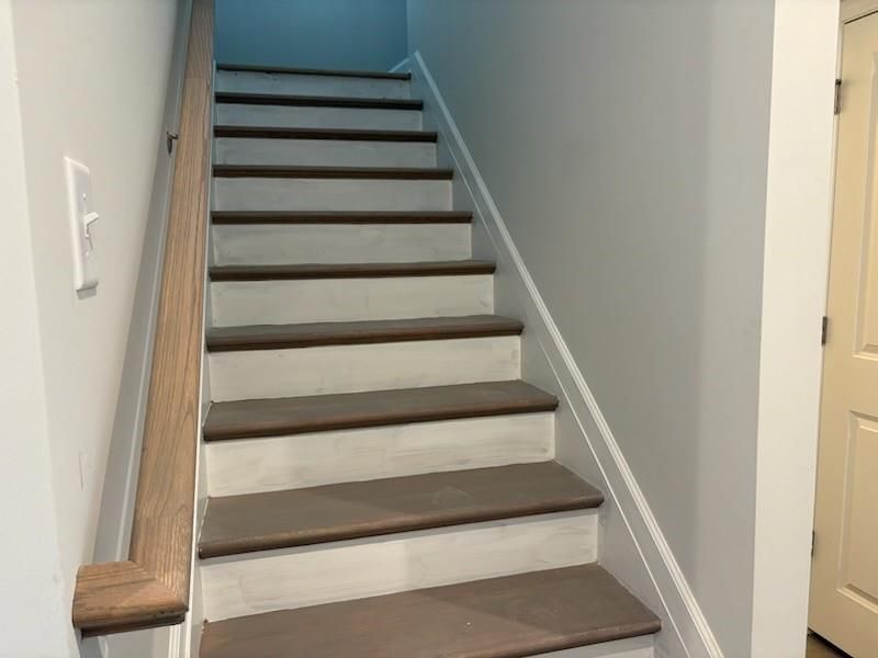 Elegant oak staircase with dark wood treads and white risers in Davidson Homes Marion A, Winder, Georgia