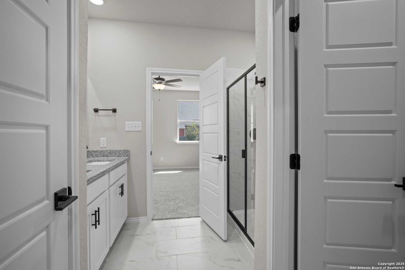 Modern master bathroom with frameless glass shower, double sink vanity, and tile flooring in Davidson Homes The Asheville E, Converse TX